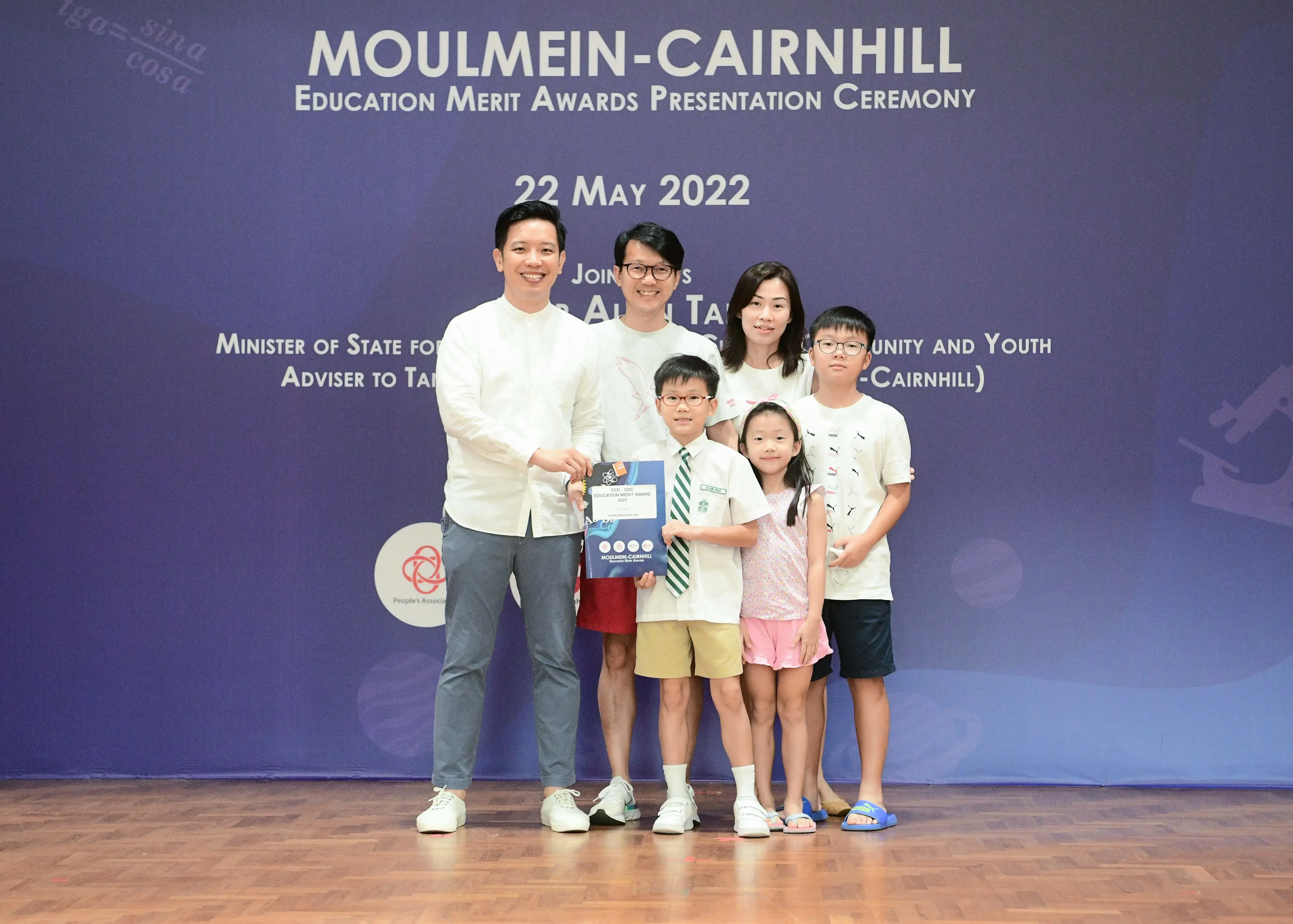 Family of five posing with an award certificate at the Moulmein-Cairnhill Education Merit Awards on 22 May 2022.