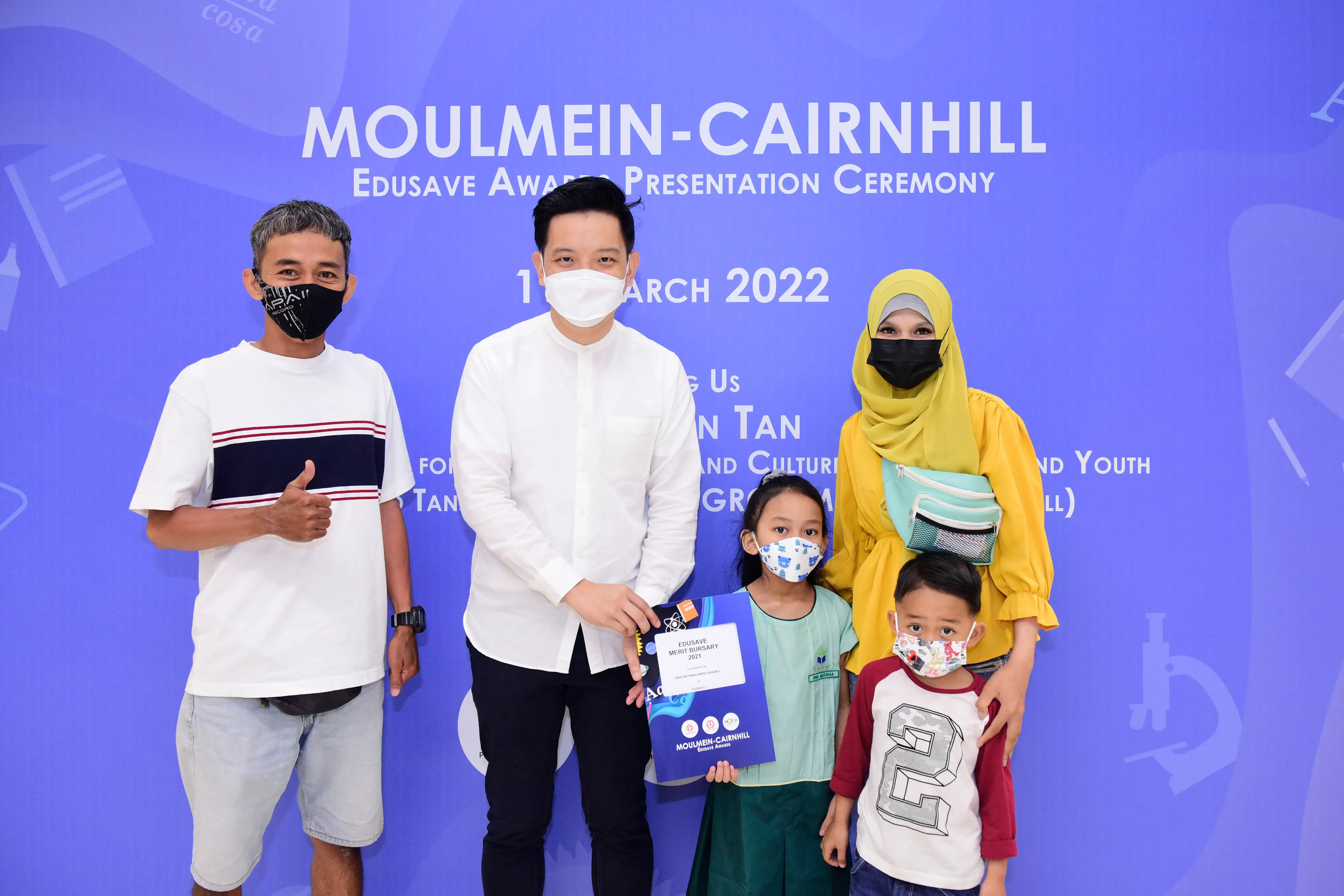 Five masked people pose at the Moulmein-Cairnhill Edusave Awards Presentation Ceremony in March 2022.