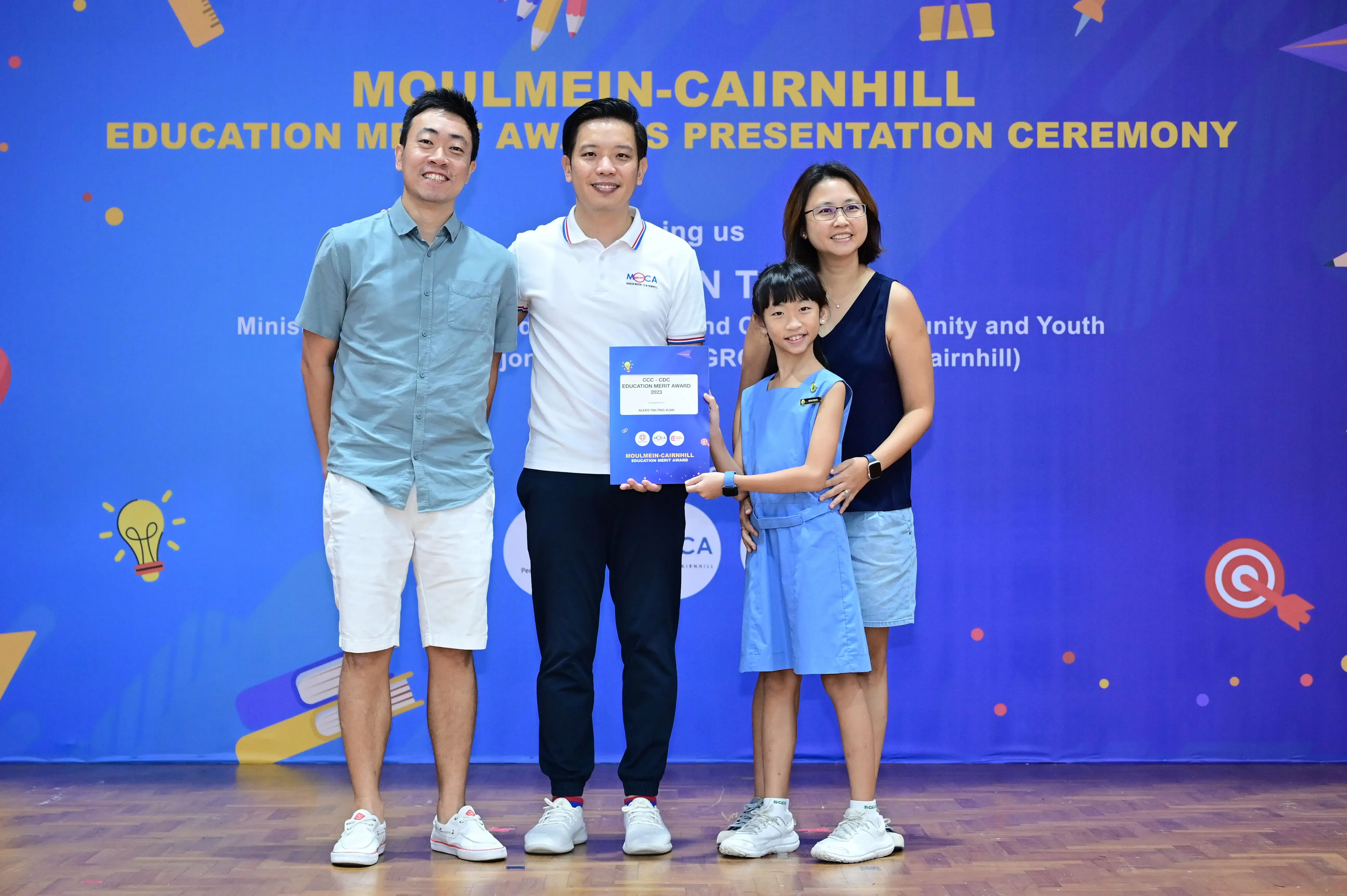 Four people pose with an award certificate at the Moulmein-Cairnhill Education Merit Awards Presentation Ceremony.