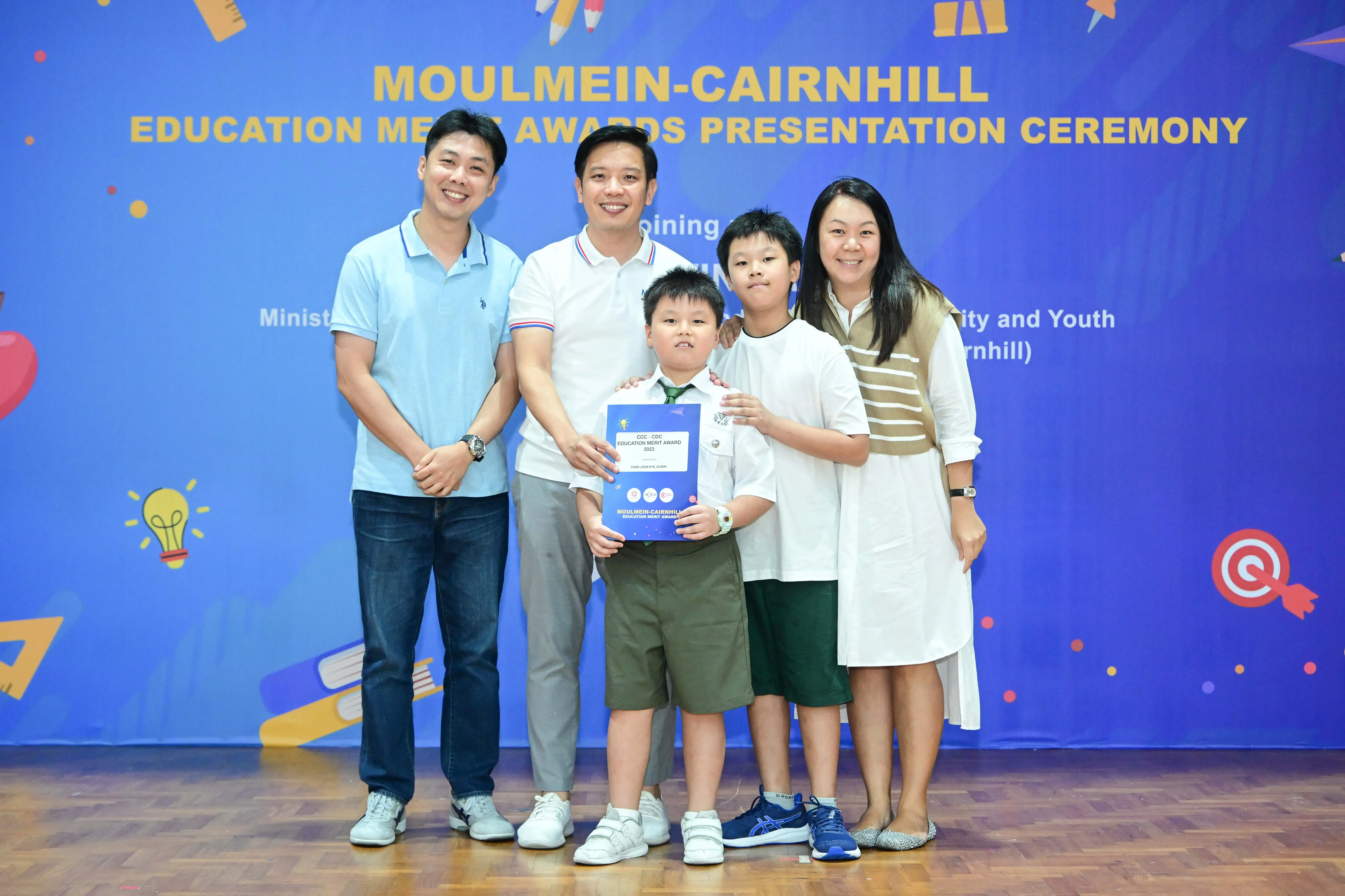 Five people pose with an award certificate at the Moulmein-Cairnhill Education Merit Awards Presentation Ceremony.