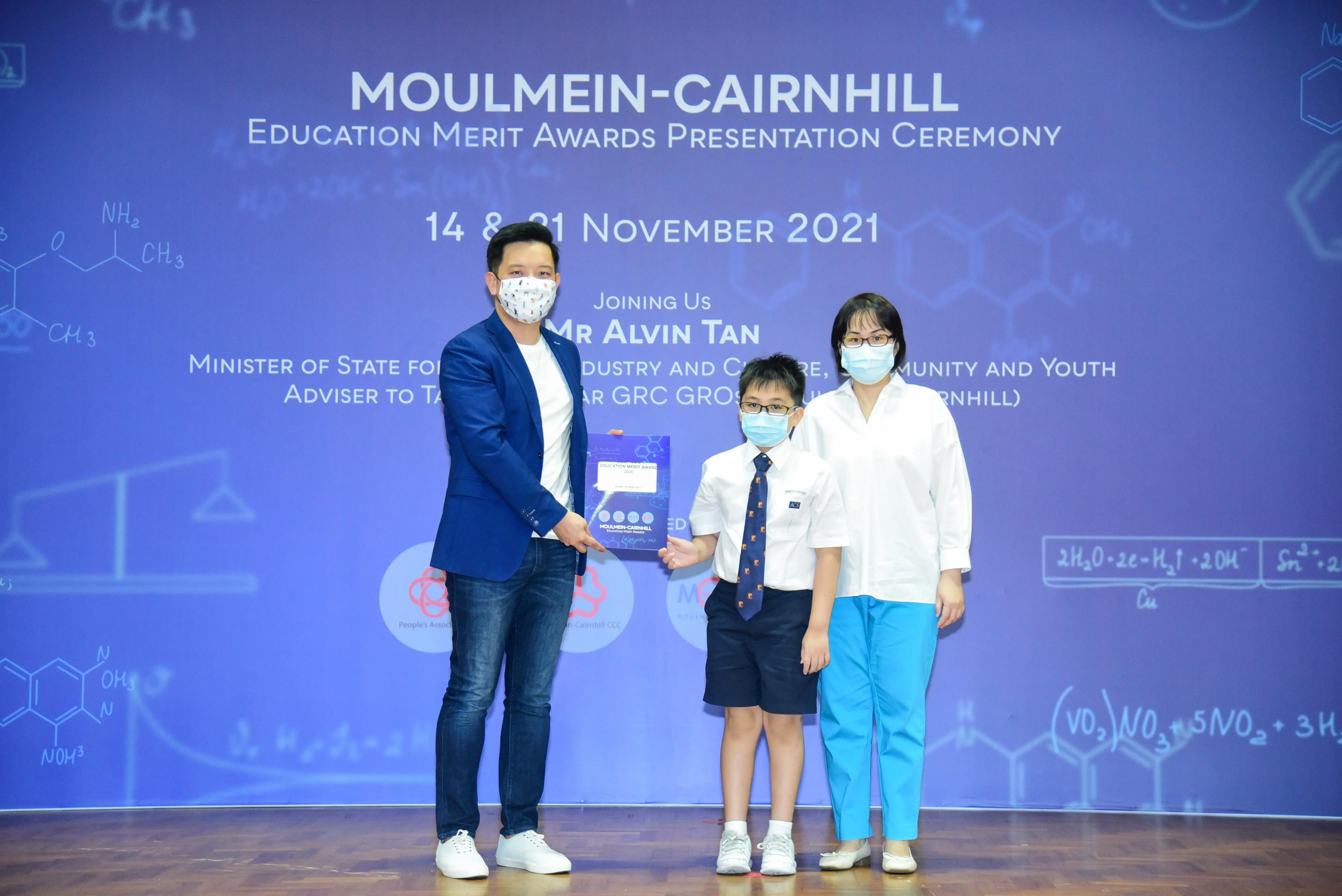 Three masked individuals pose at the Moulmein-Cairnhill Education Merit Awards Presentation Ceremony, November 2021.