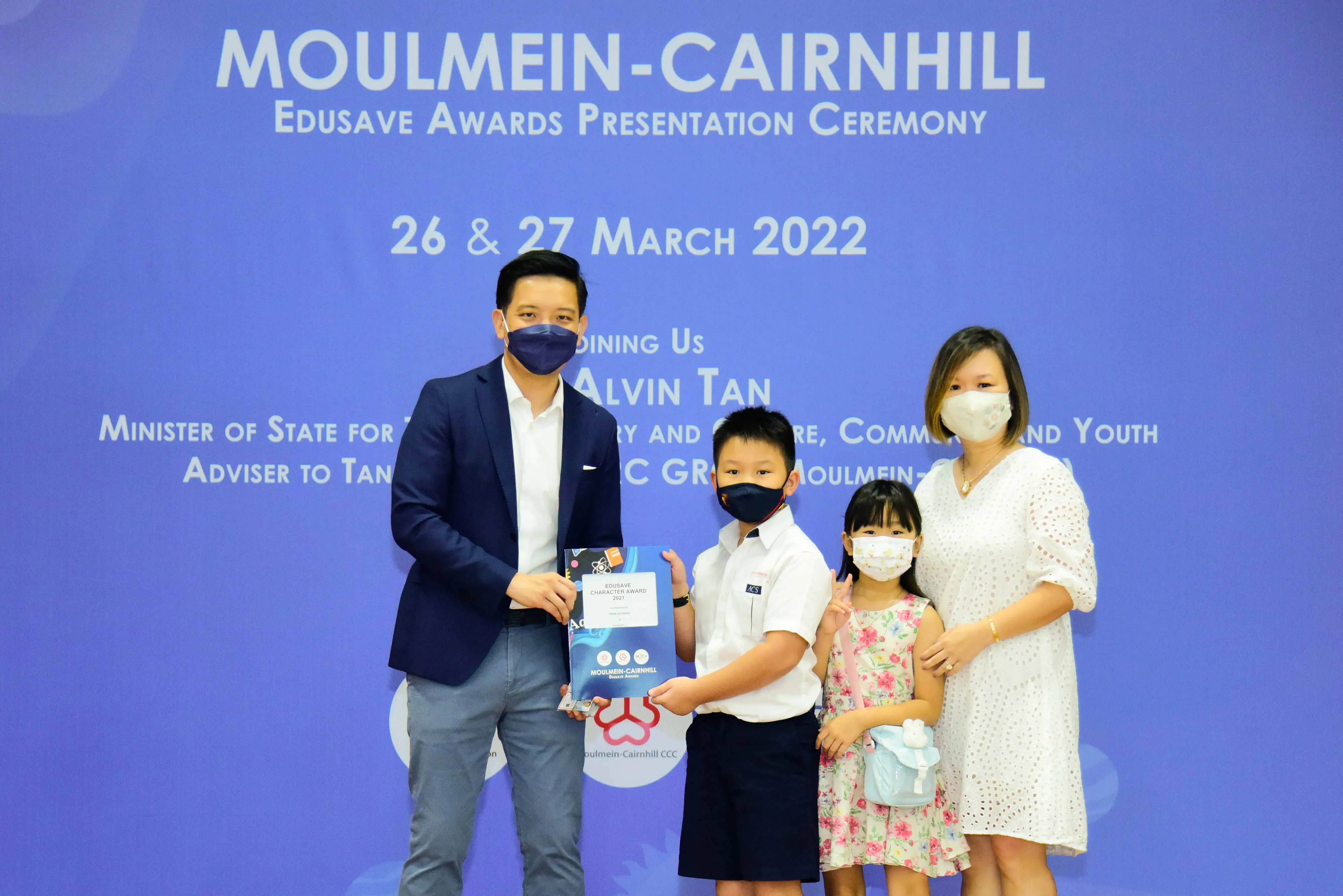Four masked people pose at the Moulmein-Cairnhill Edusave Awards Presentation Ceremony on 27 March 2022.