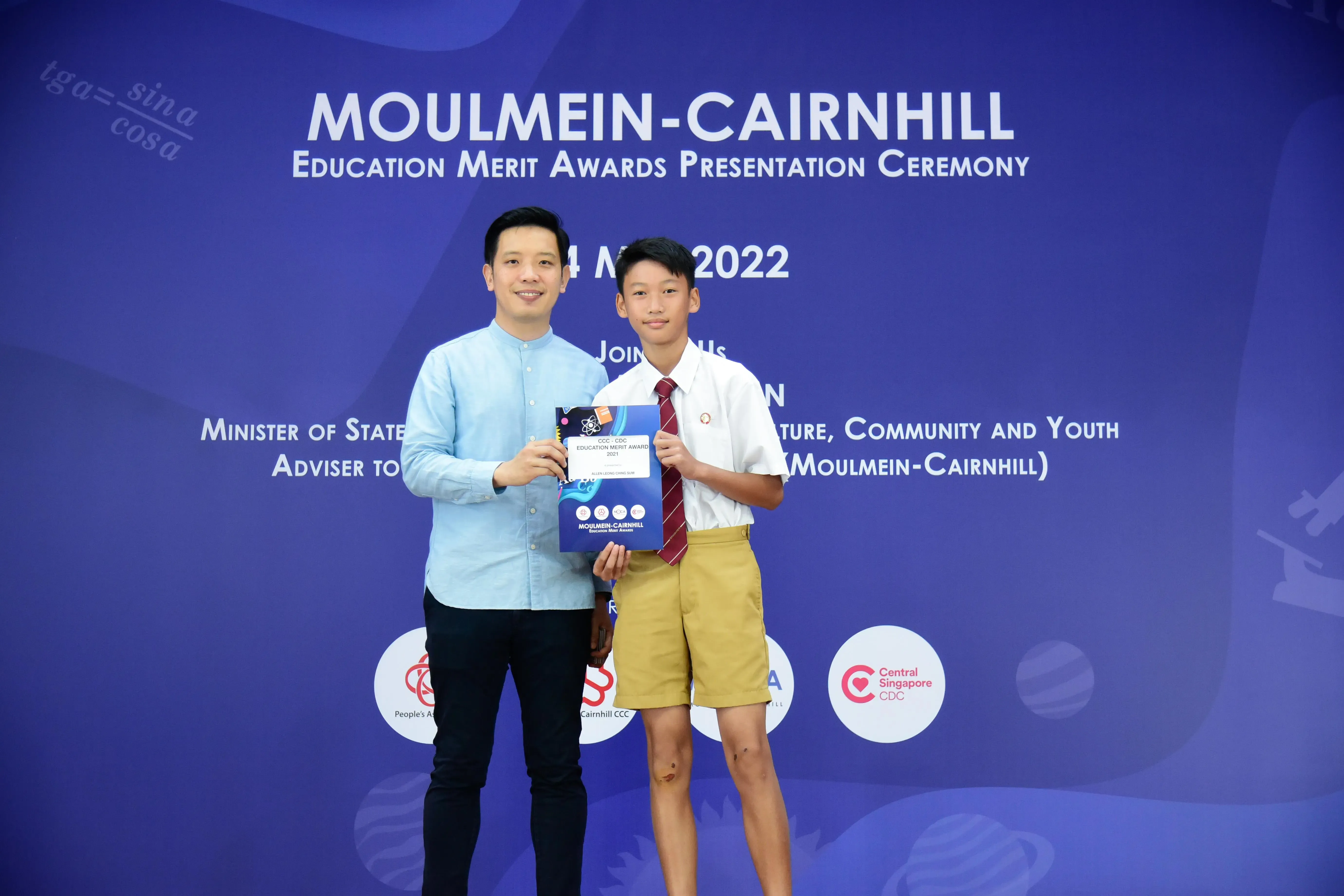 Adult and young student holding an award certificate at the Moulmein-Cairnhill Education Merit Awards 2022.
