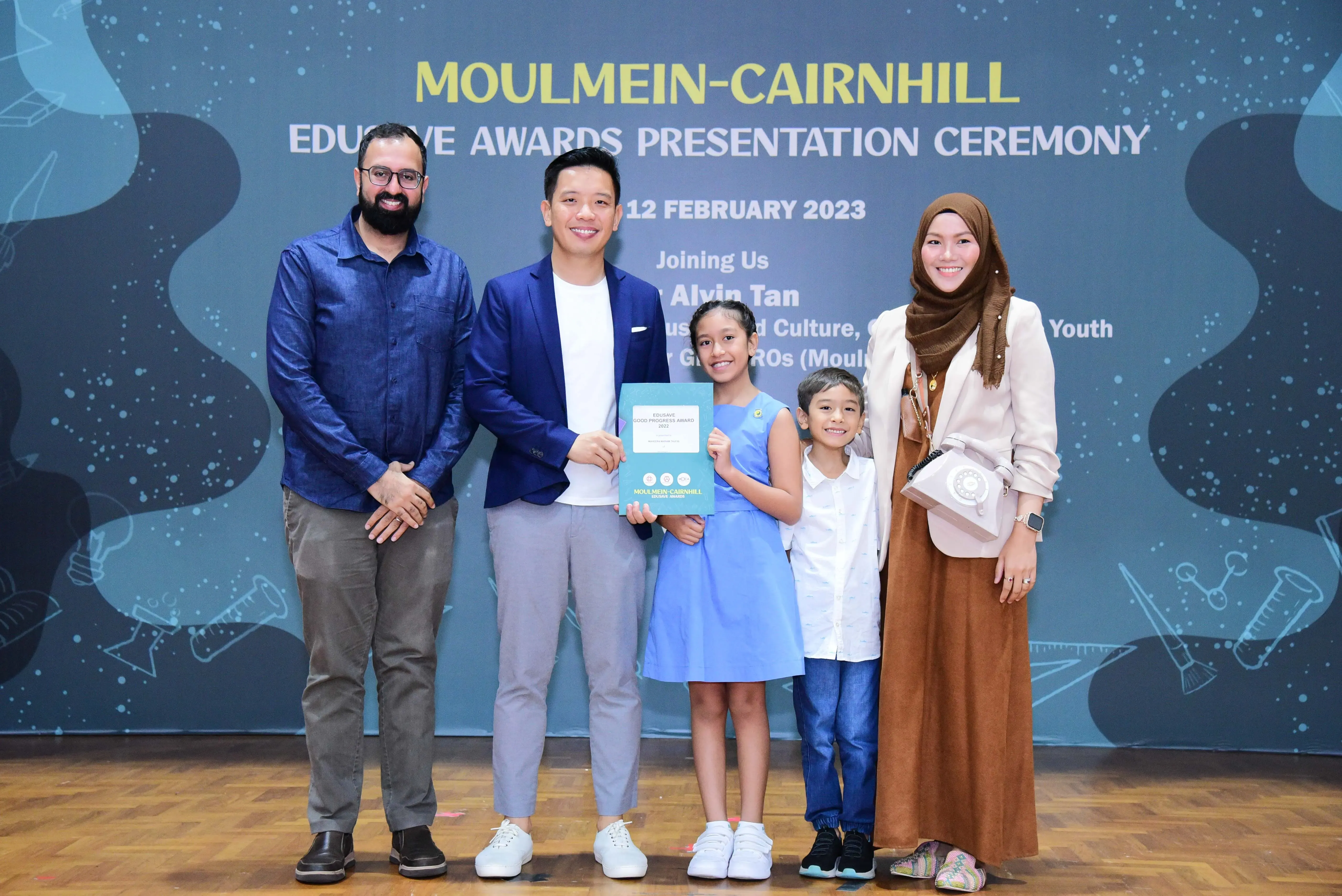 Five people pose with an award certificate at the Moulmein-Cairnhill Edusave Awards Presentation Ceremony on 12 February 2023.