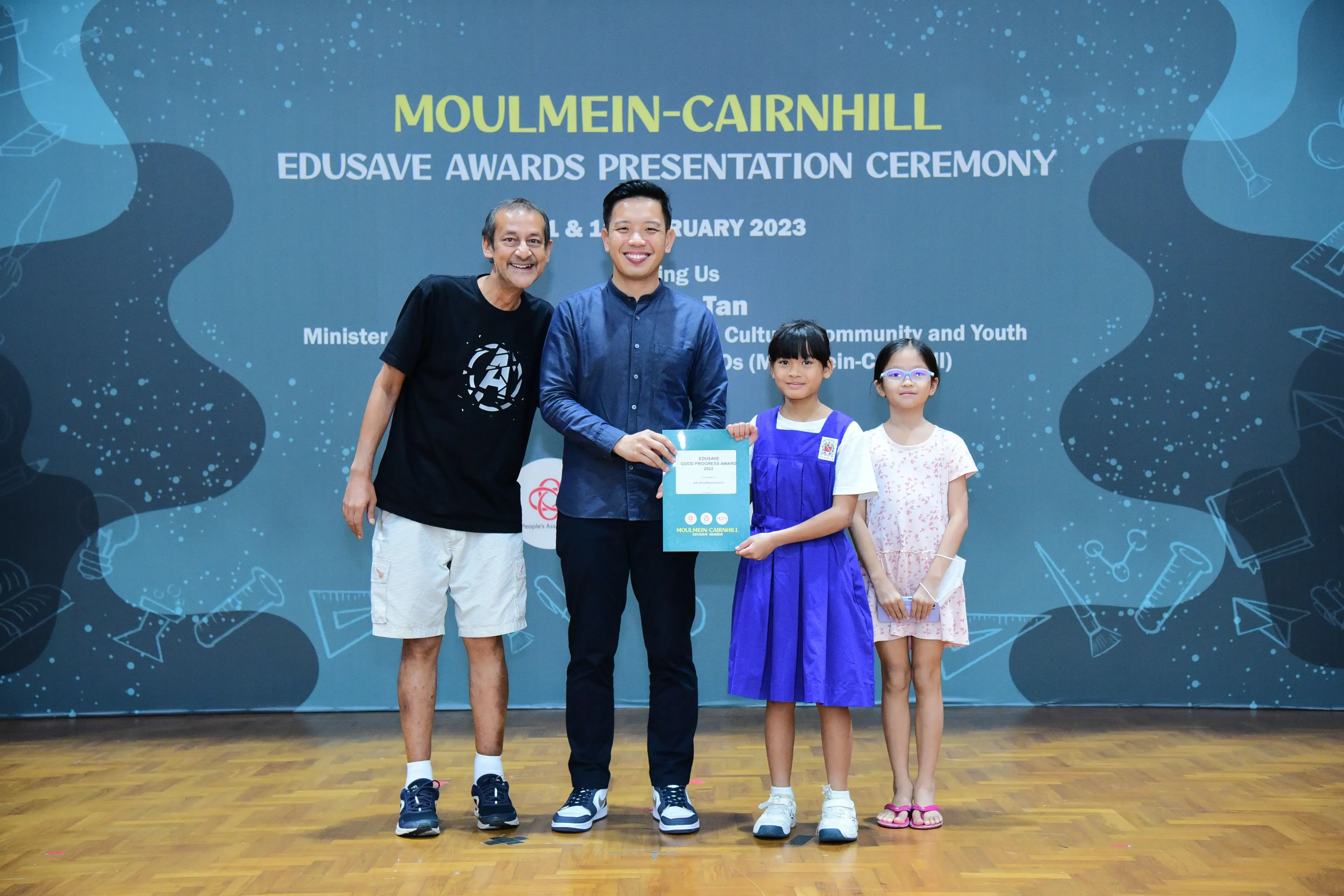 Two adults and two young girls pose at the Moulmein-Cairnhill Edusave Awards Presentation Ceremony 2023.