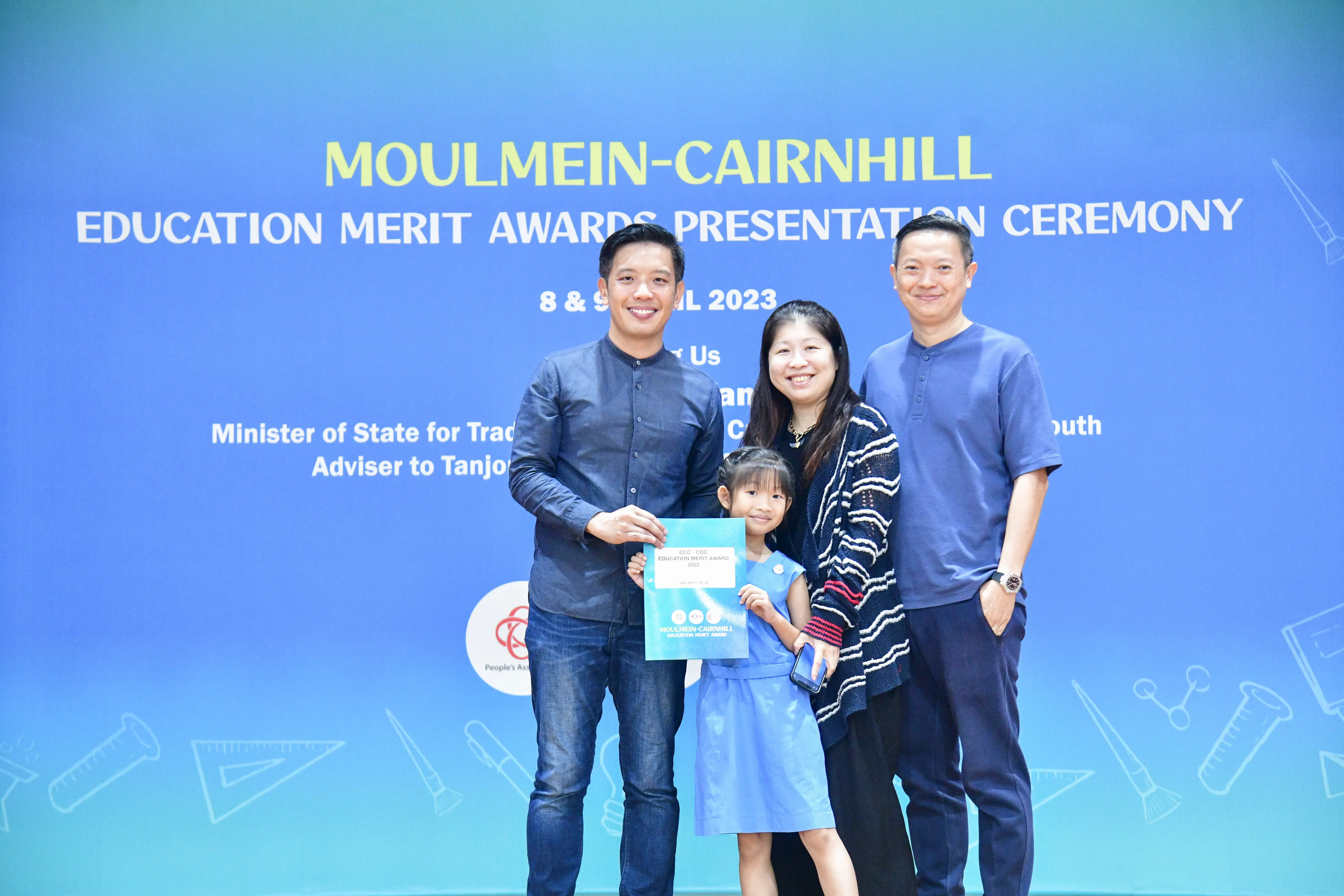 Three adults and a young girl pose with an award certificate at the Moulmein-Cairnhill Education Merit Awards 2023.