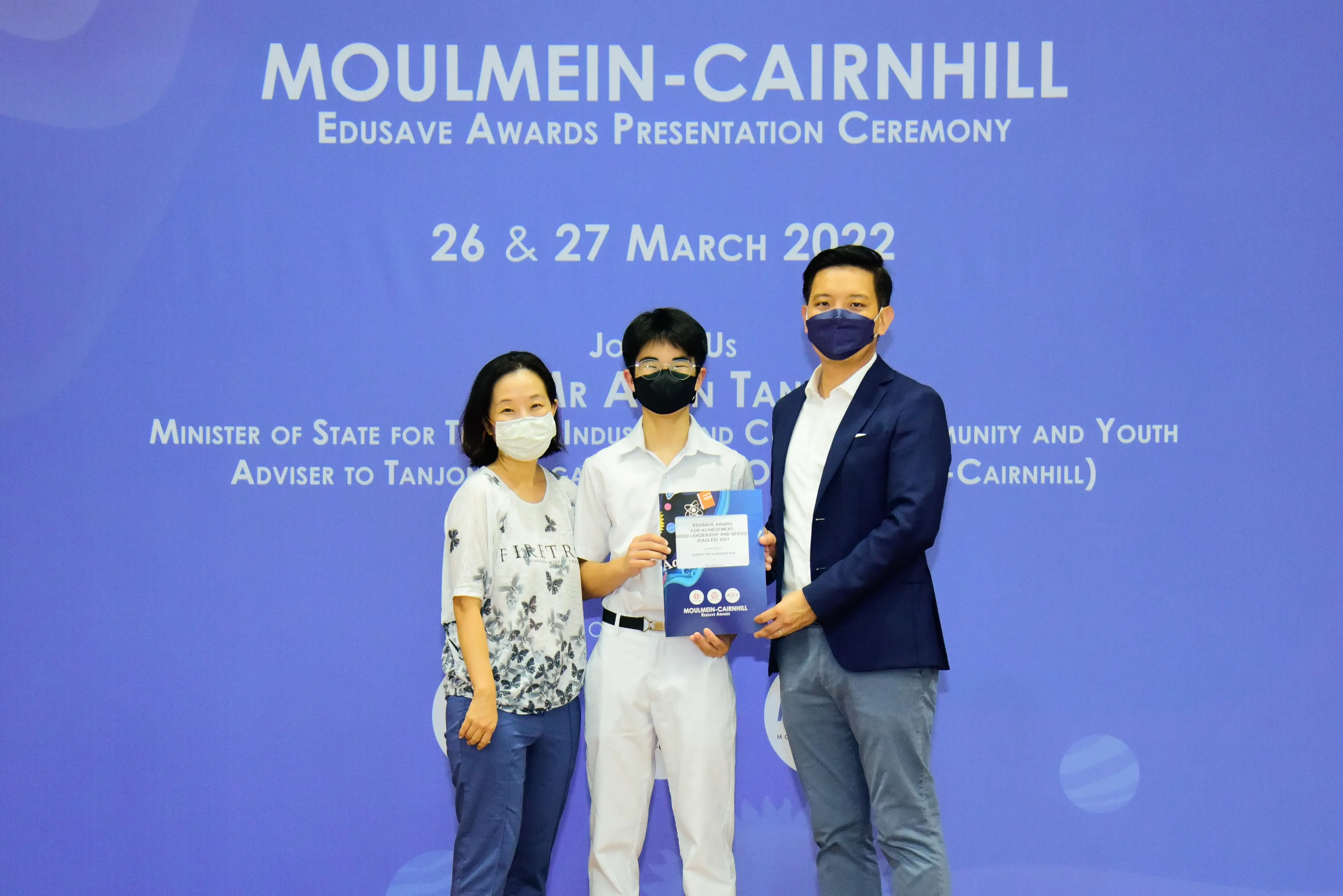 Three masked people pose at the Moulmein-Cairnhill Edusave Awards Presentation Ceremony on 26-27 March 2022.