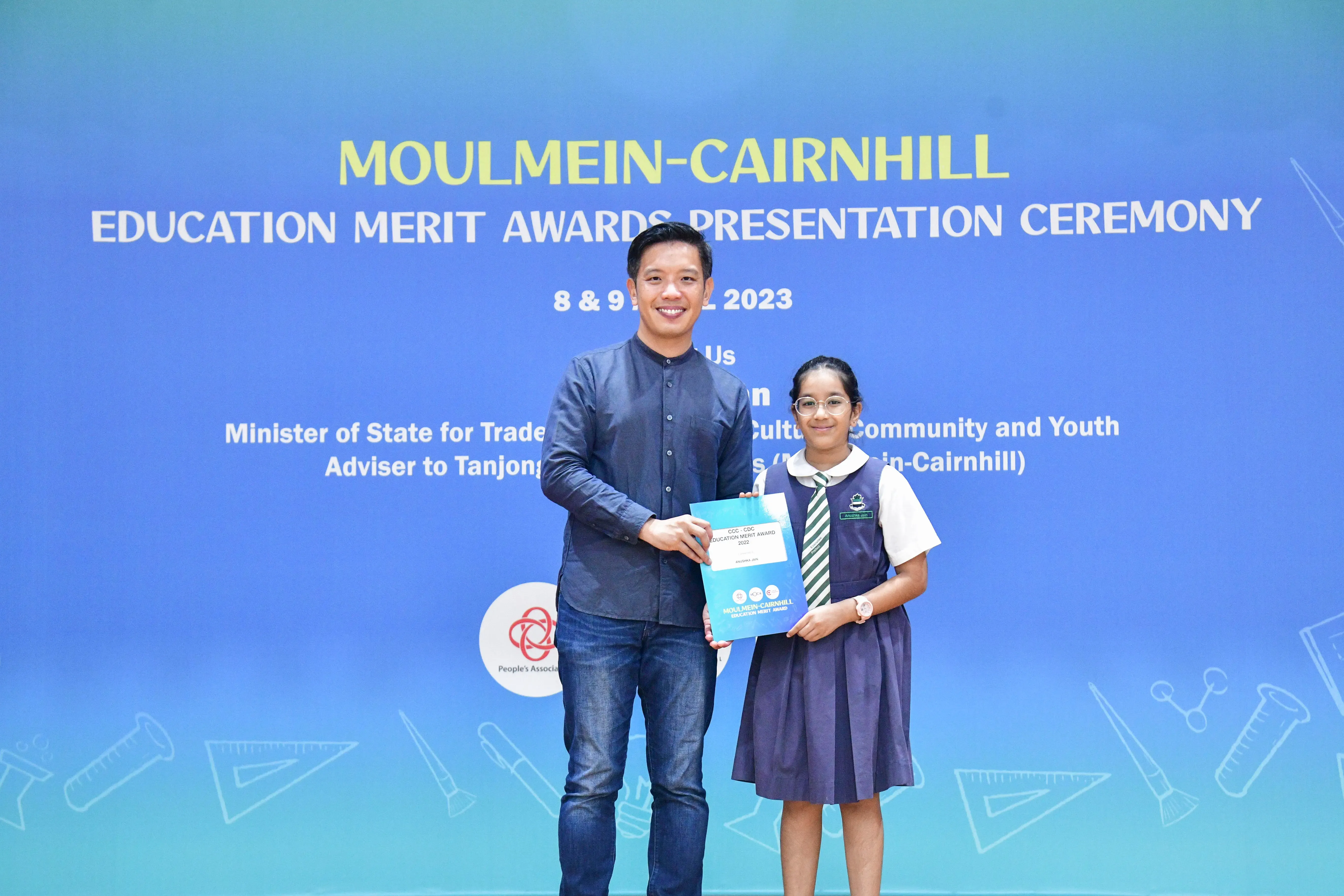 A man and a young girl in school uniform hold an award certificate at the Moulmein-Cairnhill Education Merit Awards 2023.