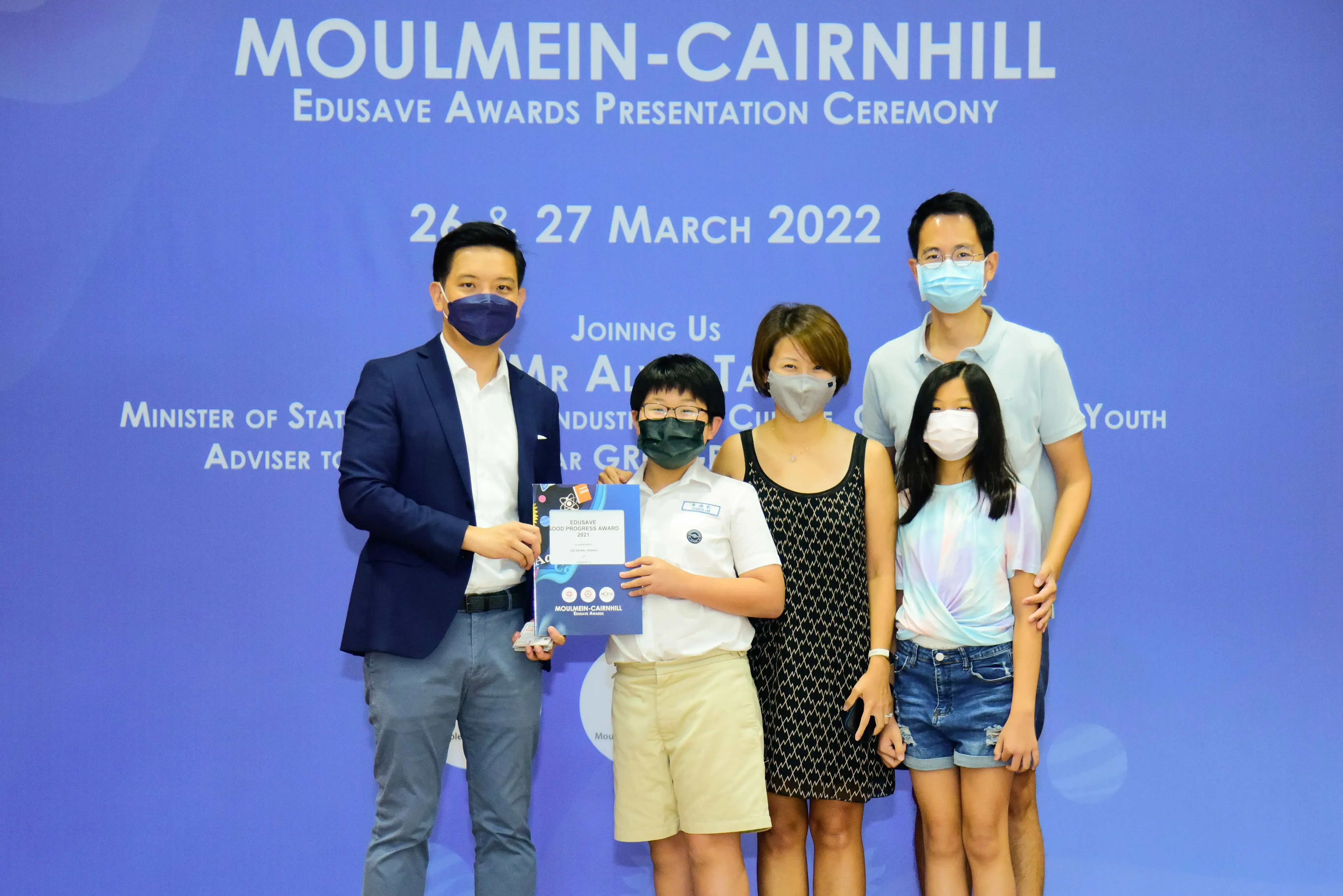Five masked people pose at the Moulmein-Cairnhill Edusave Awards Presentation Ceremony on 26-27 March 2022.