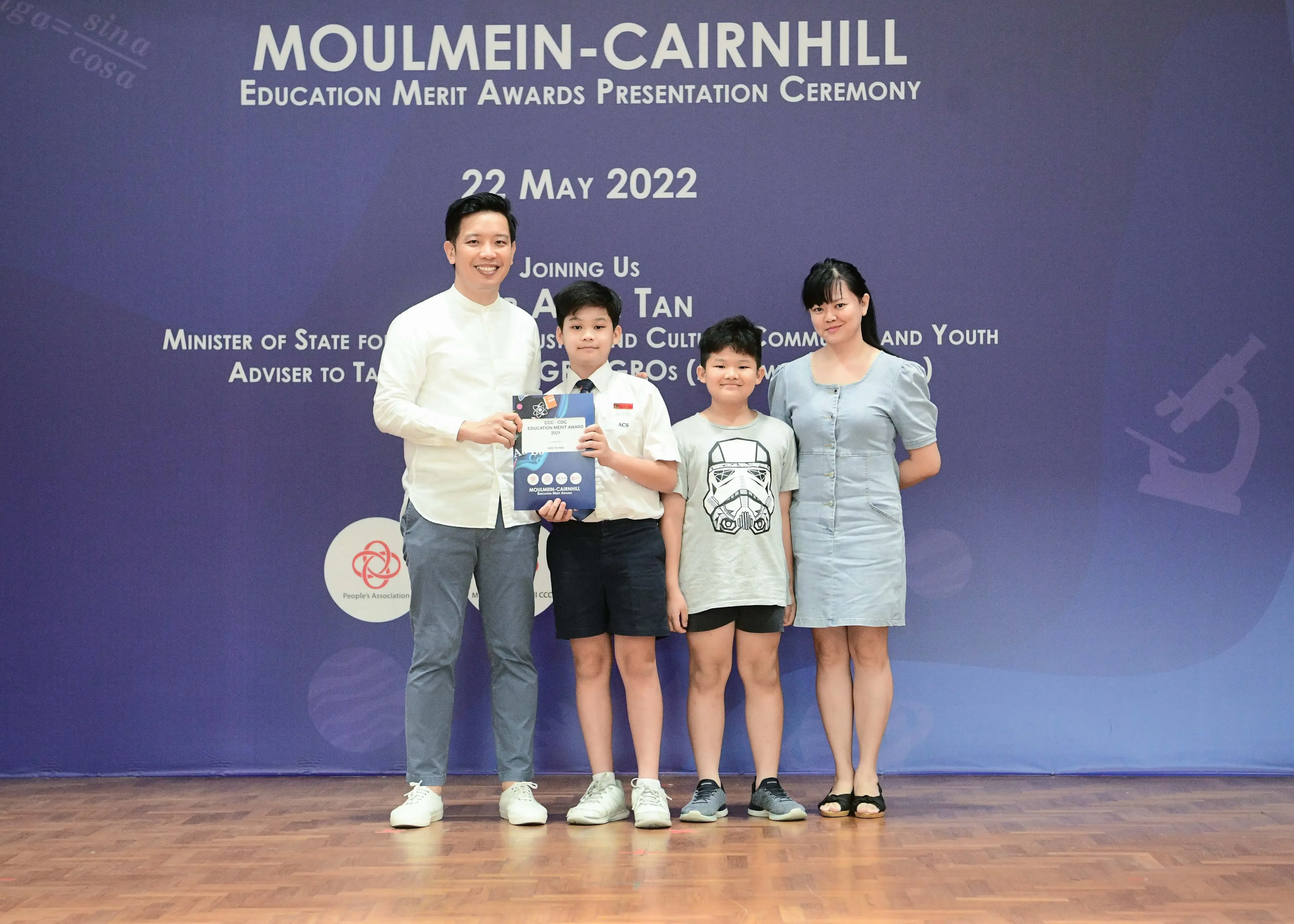 Two adults and two children pose at the Moulmein-Cairnhill Education Merit Awards ceremony on 22 May 2022.