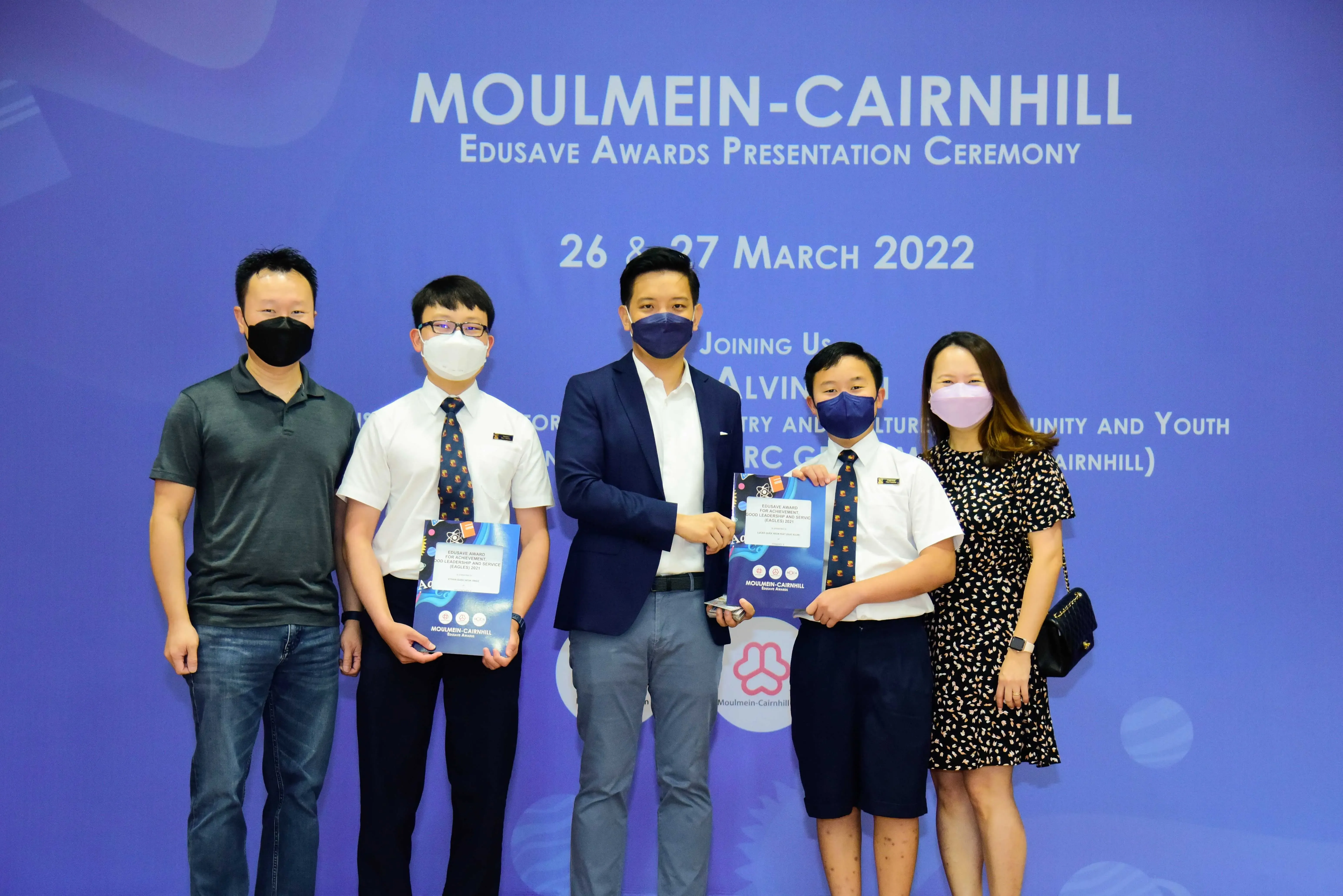 Five masked people pose at the Moulmein-Cairnhill Edusave Awards Presentation Ceremony on 26-27 March 2022.