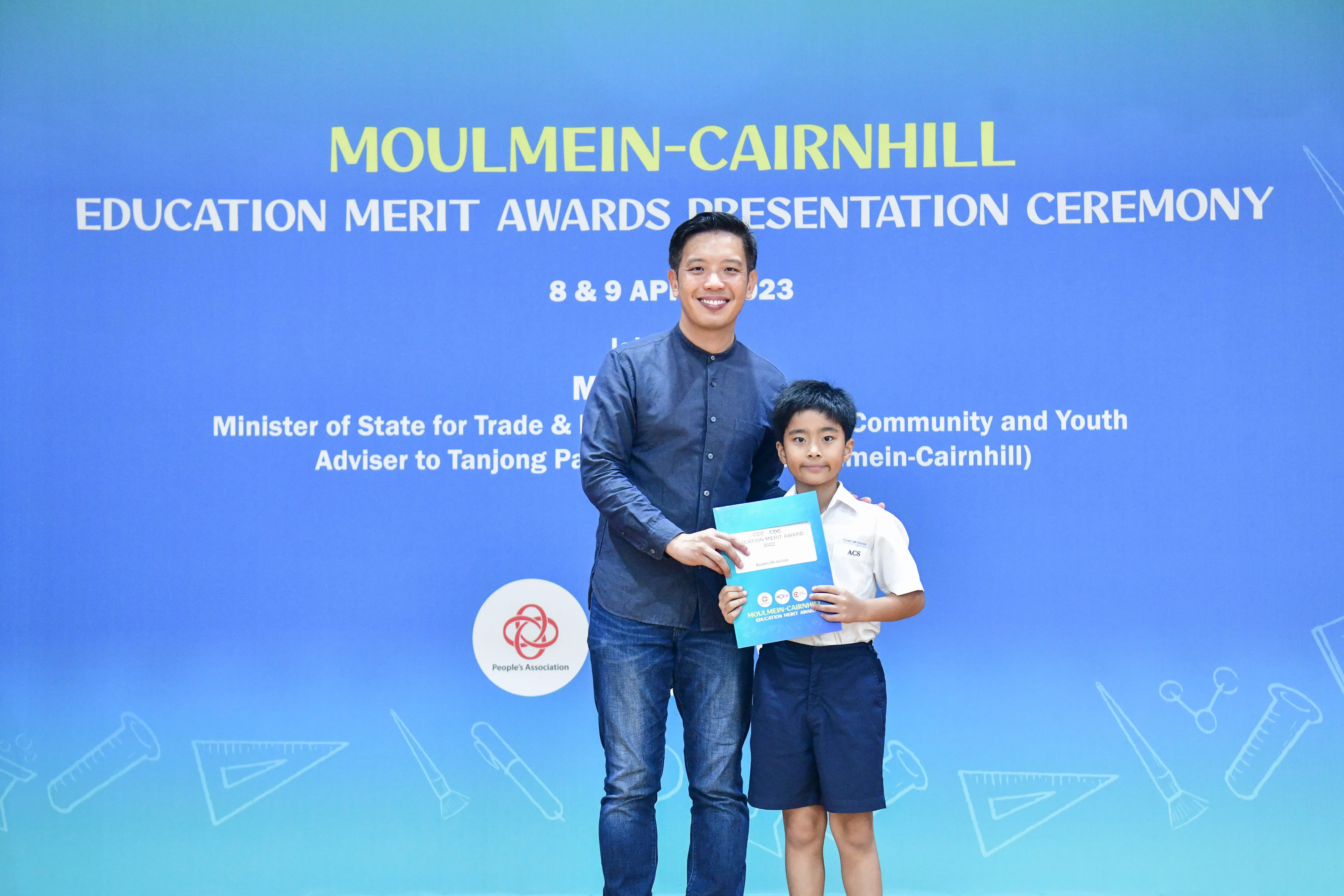 A man and a young boy pose together holding a certificate at the Moulmein-Cairnhill Education Merit Awards 2023.