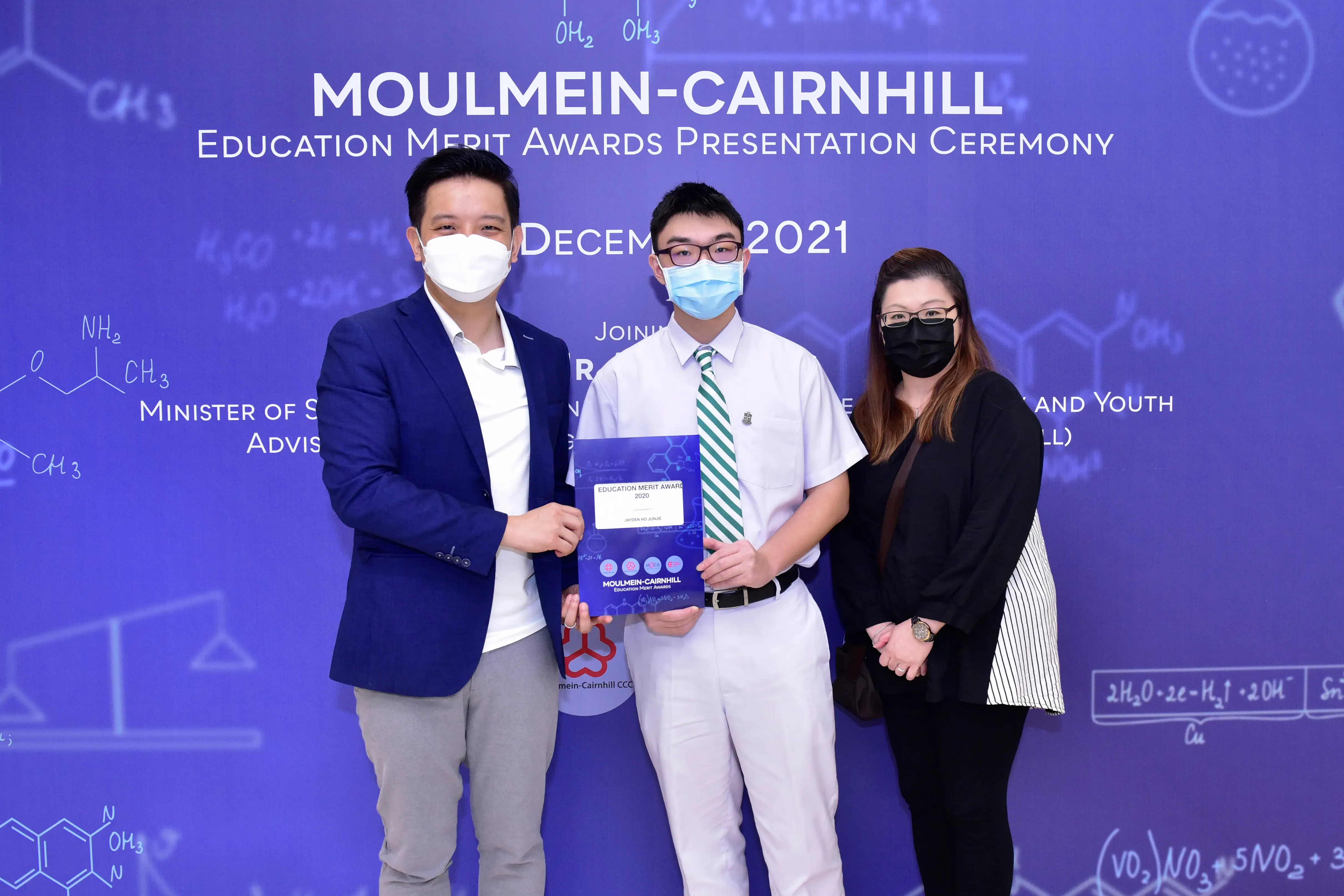Three masked people pose at the Moulmein-Cairnhill Education Merit Awards Ceremony in December 2021.