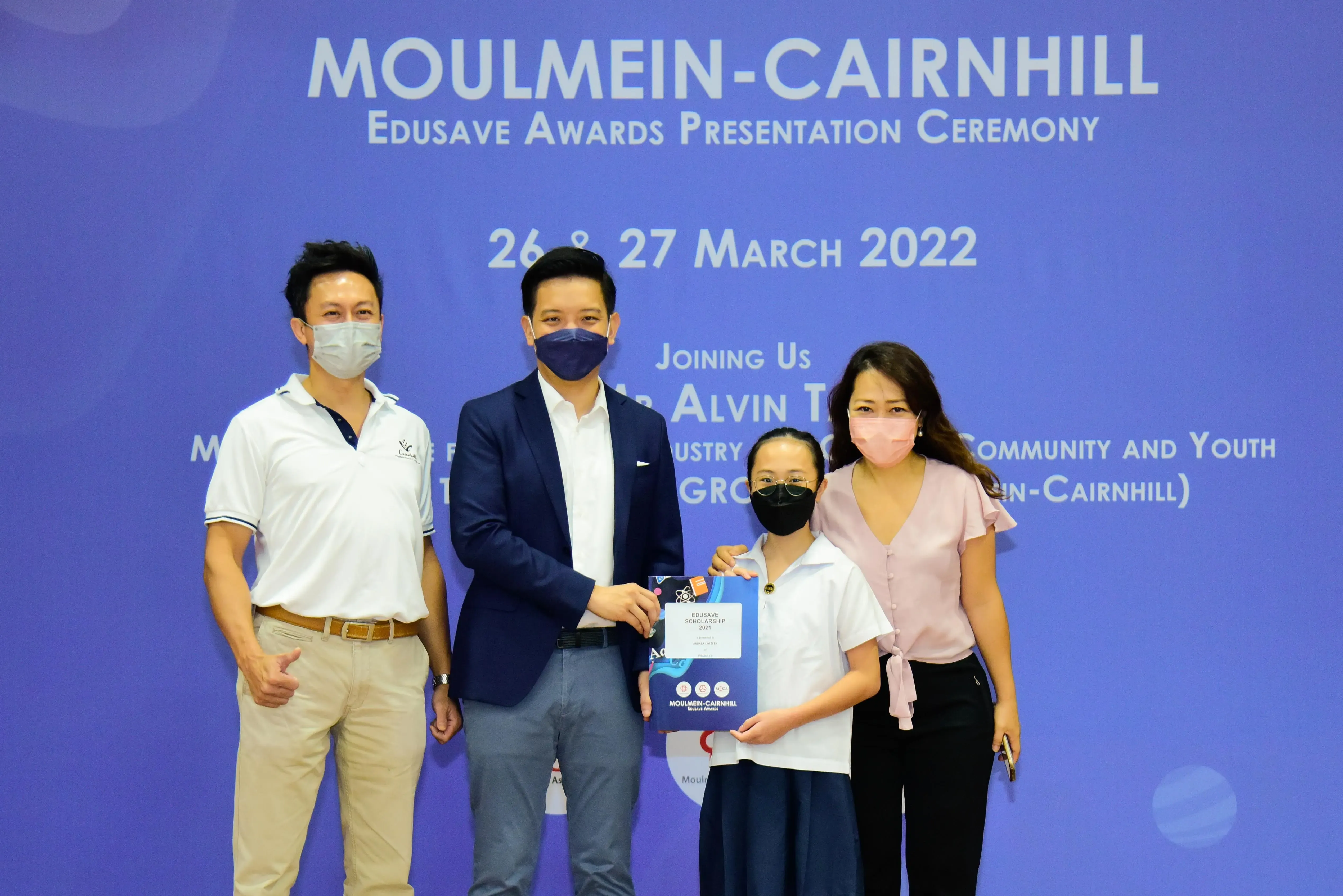 Four masked people pose at the Moulmein-Cairnhill Edusave Awards Presentation Ceremony on 26-27 March 2022.