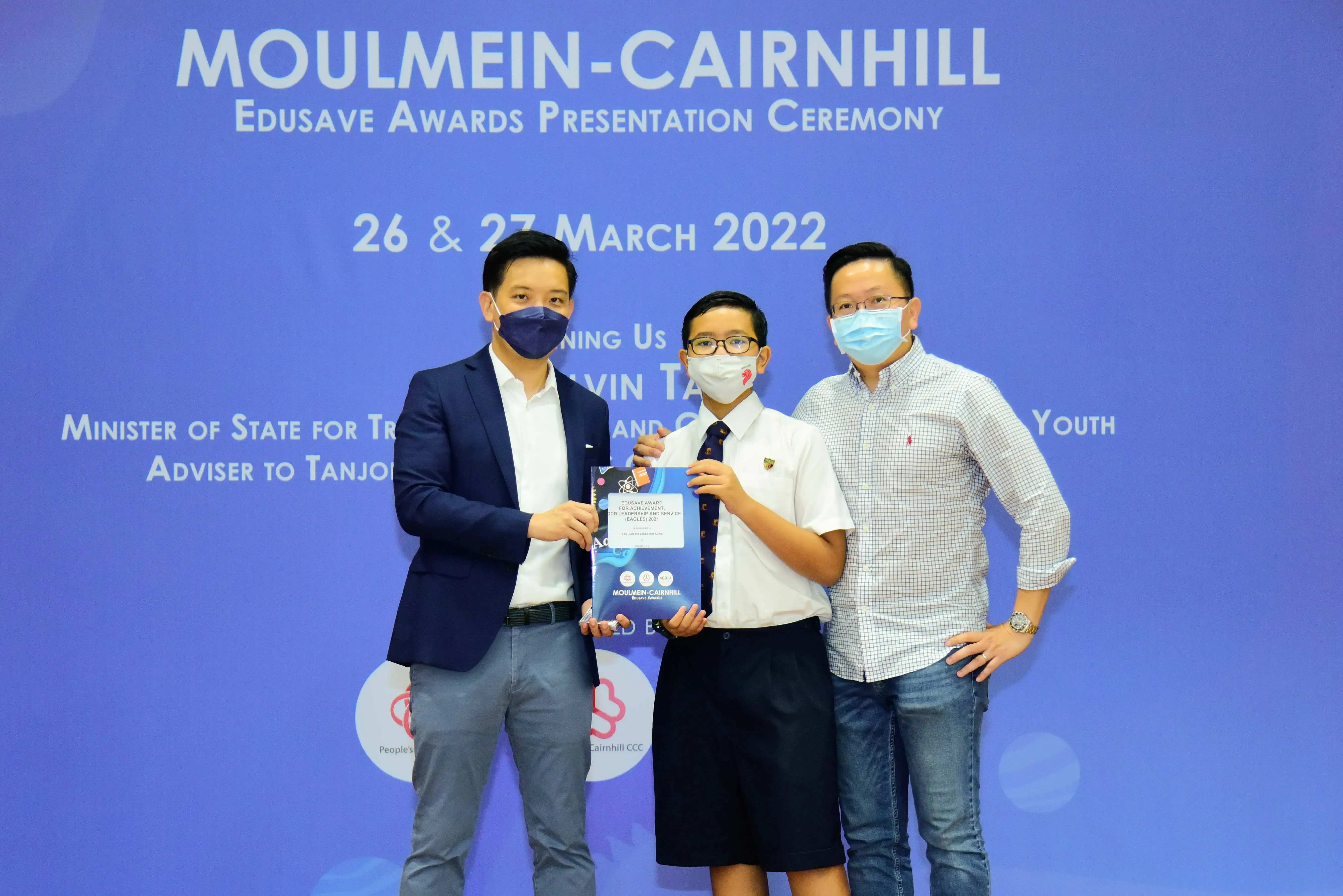 Three masked individuals pose at the Moulmein-Cairnhill Edusave Awards Presentation Ceremony on 26-27 March 2022.