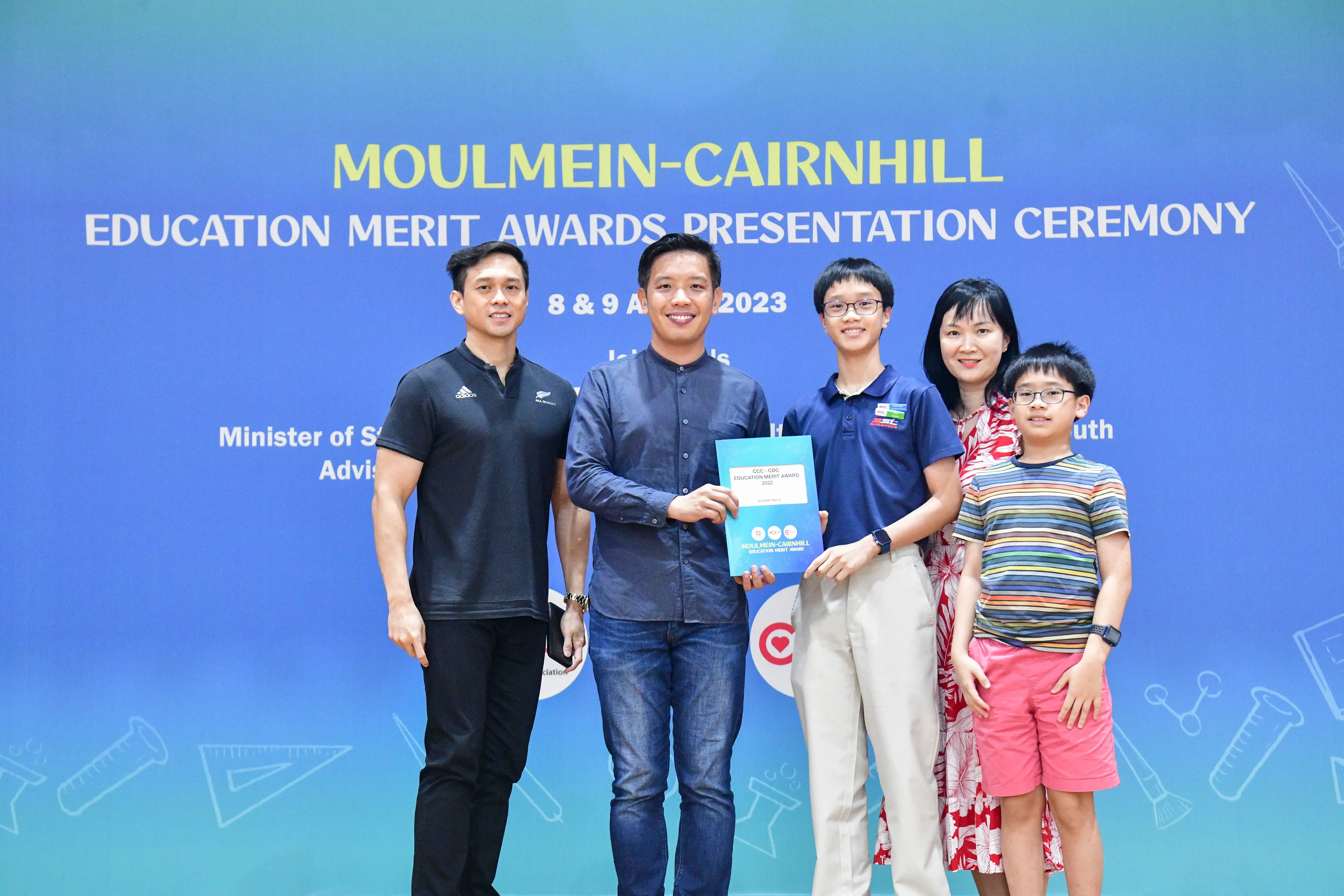 Five people pose holding a certificate at the Moulmein-Cairnhill Education Merit Awards Ceremony, August 2023.