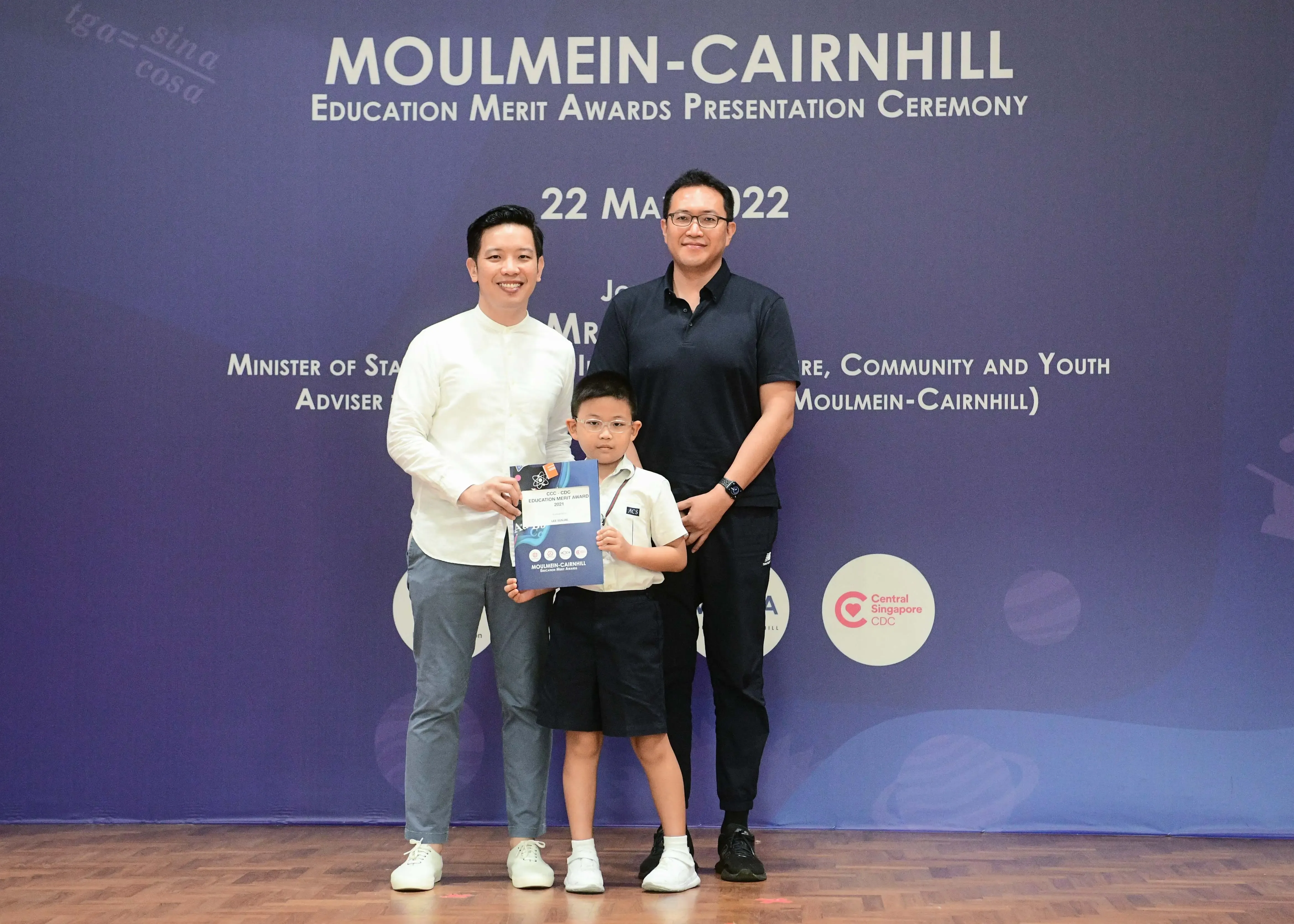 Two men and a young boy pose at the Moulmein-Cairnhill Education Merit Awards Ceremony on 22 May 2022.