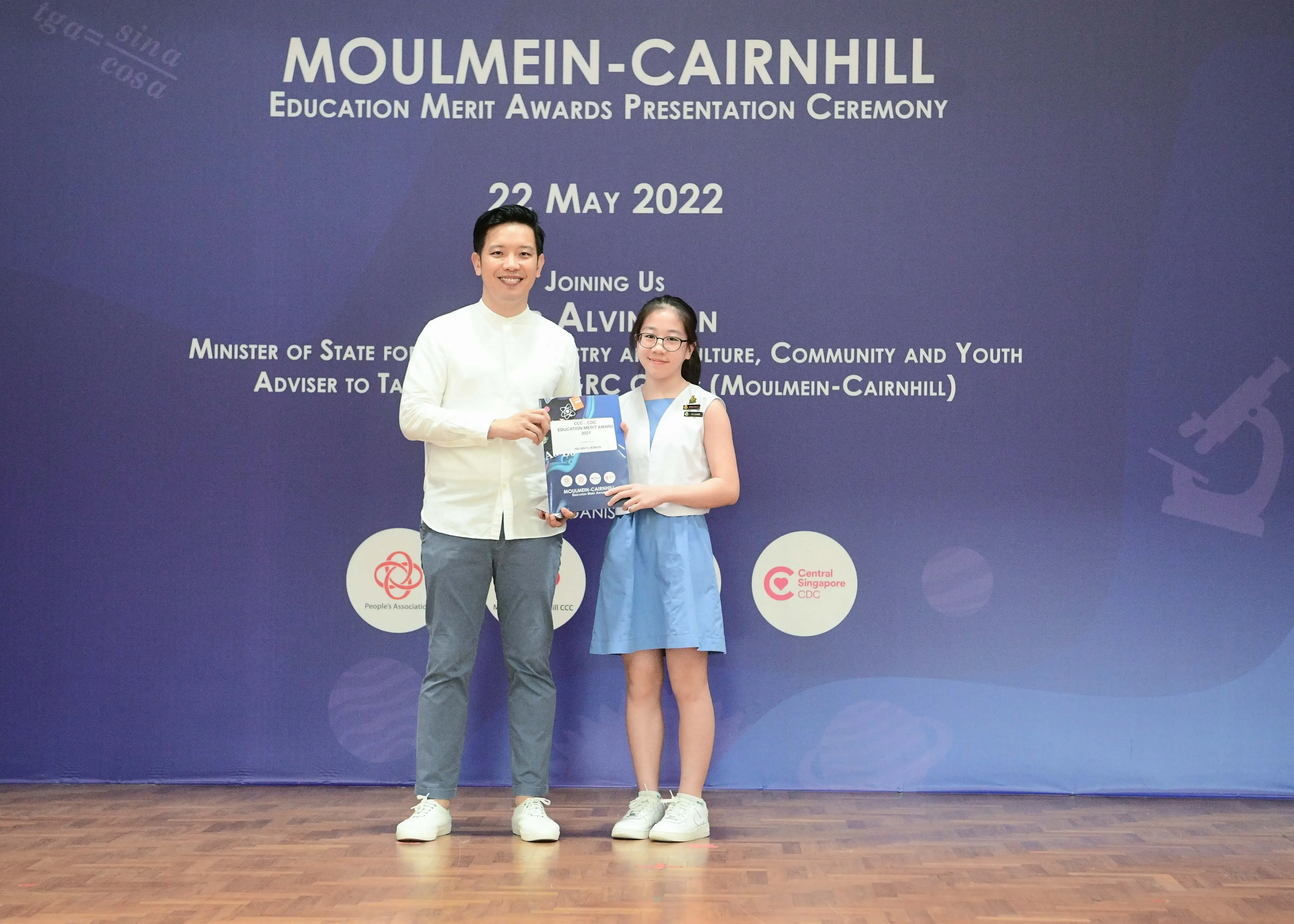 A man and a young girl pose with an award at the Moulmein-Cairnhill Education Merit Awards Ceremony on 22 May 2022.