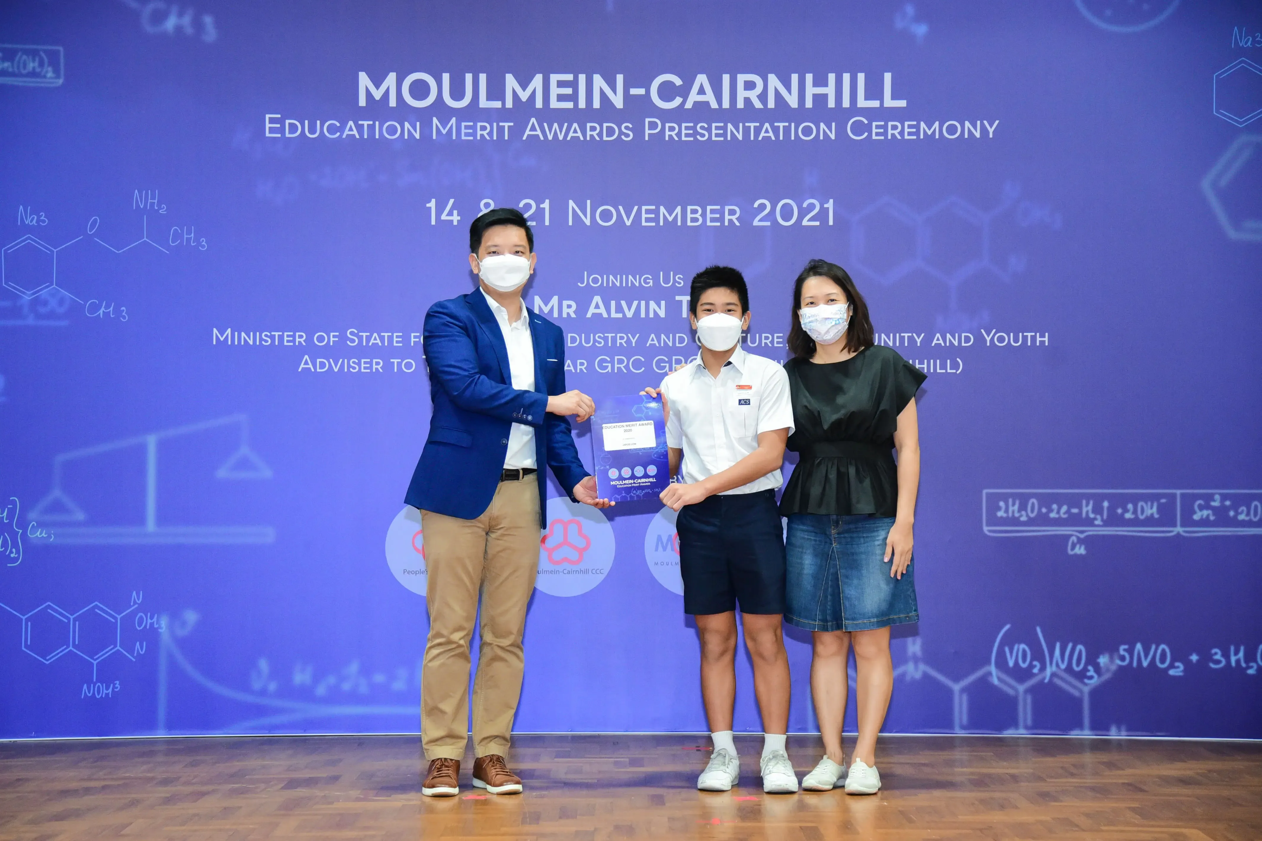 Three masked people pose at the Moulmein-Cairnhill Education Merit Awards ceremony on 14 and 21 November 2021.