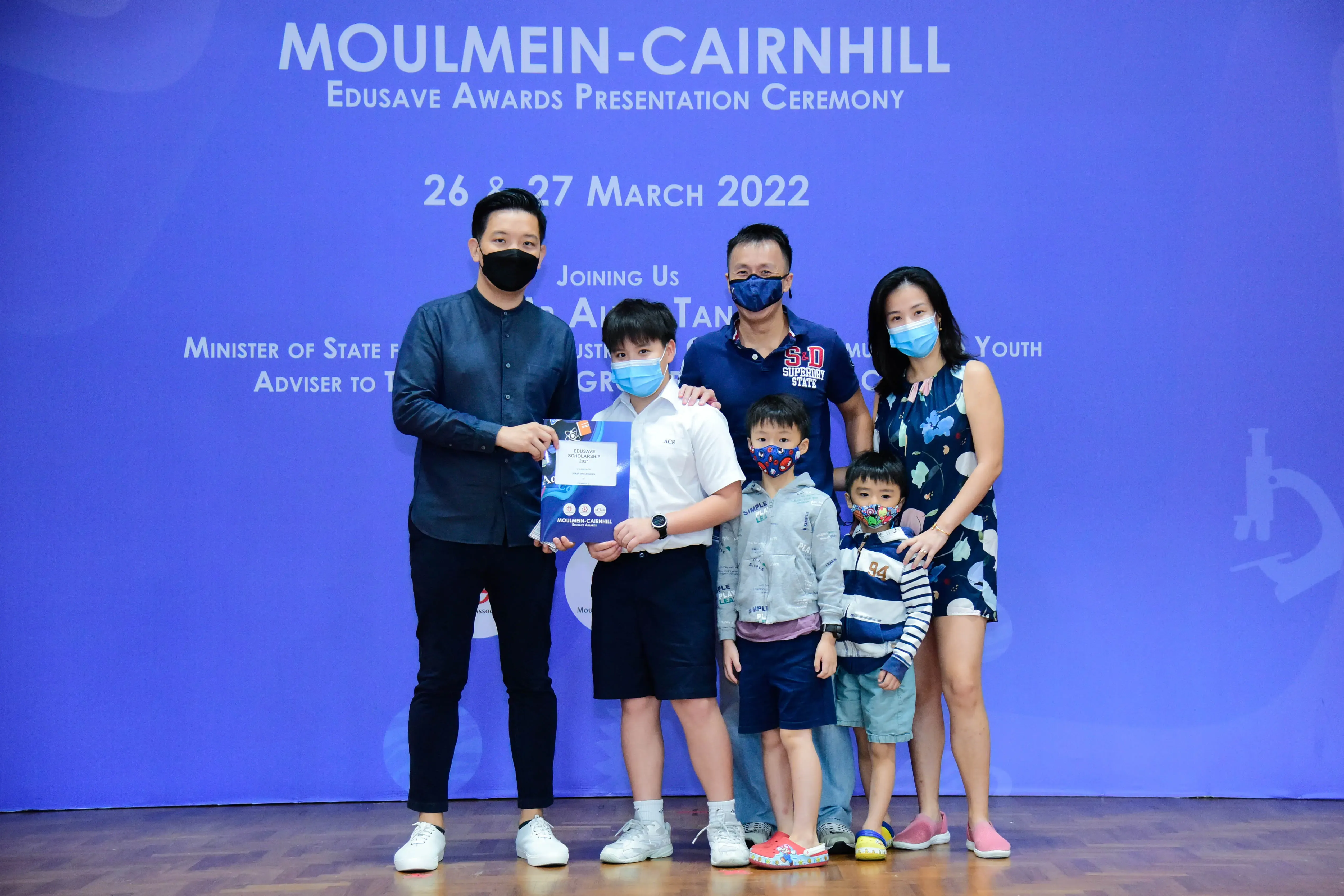 Five masked people pose at the Moulmein-Cairnhill Edusave Awards Presentation Ceremony on 26-27 March 2022.
