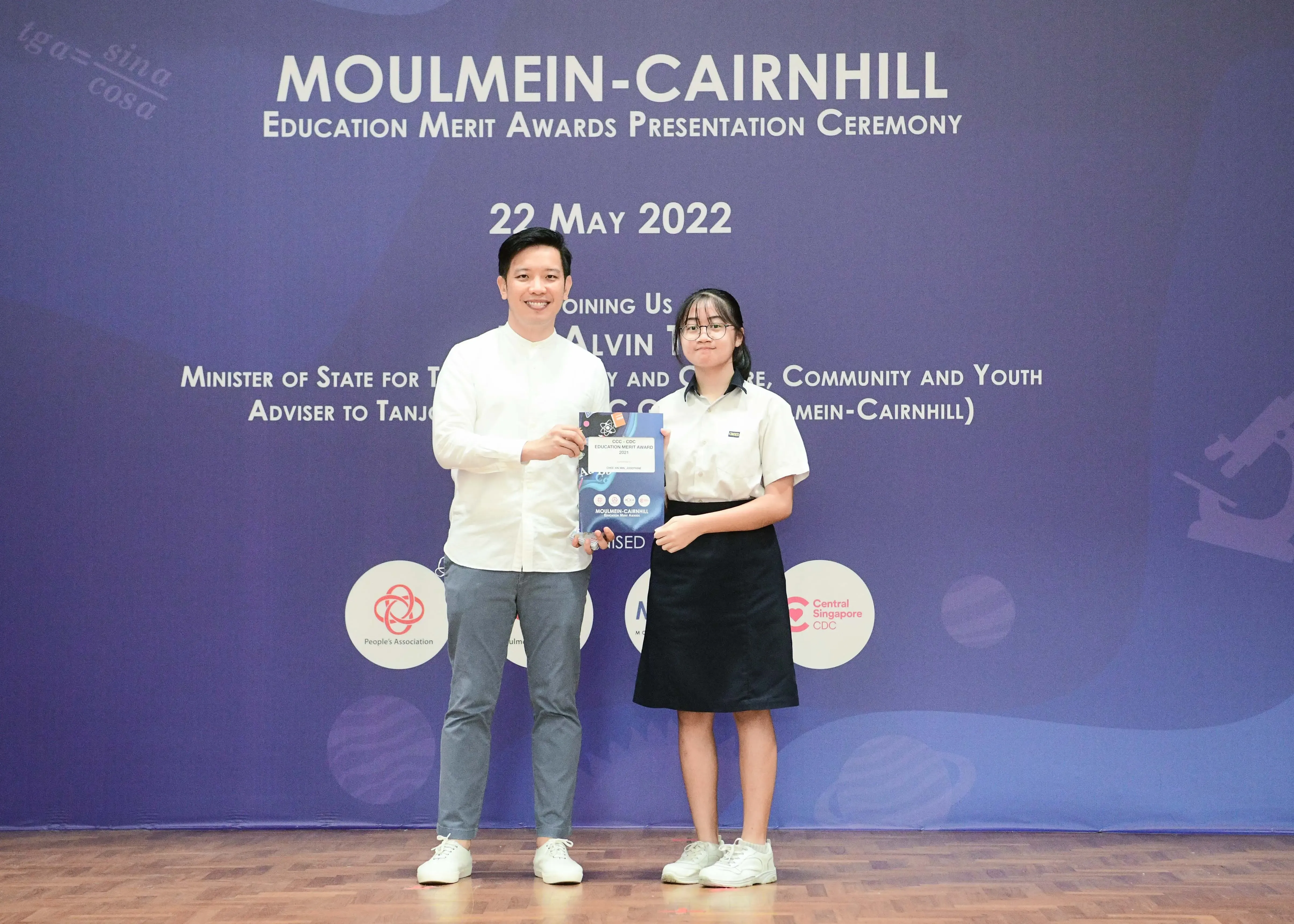 Two people pose holding an award at the Moulmein-Cairnhill Education Merit Awards Ceremony on 22 May 2022.