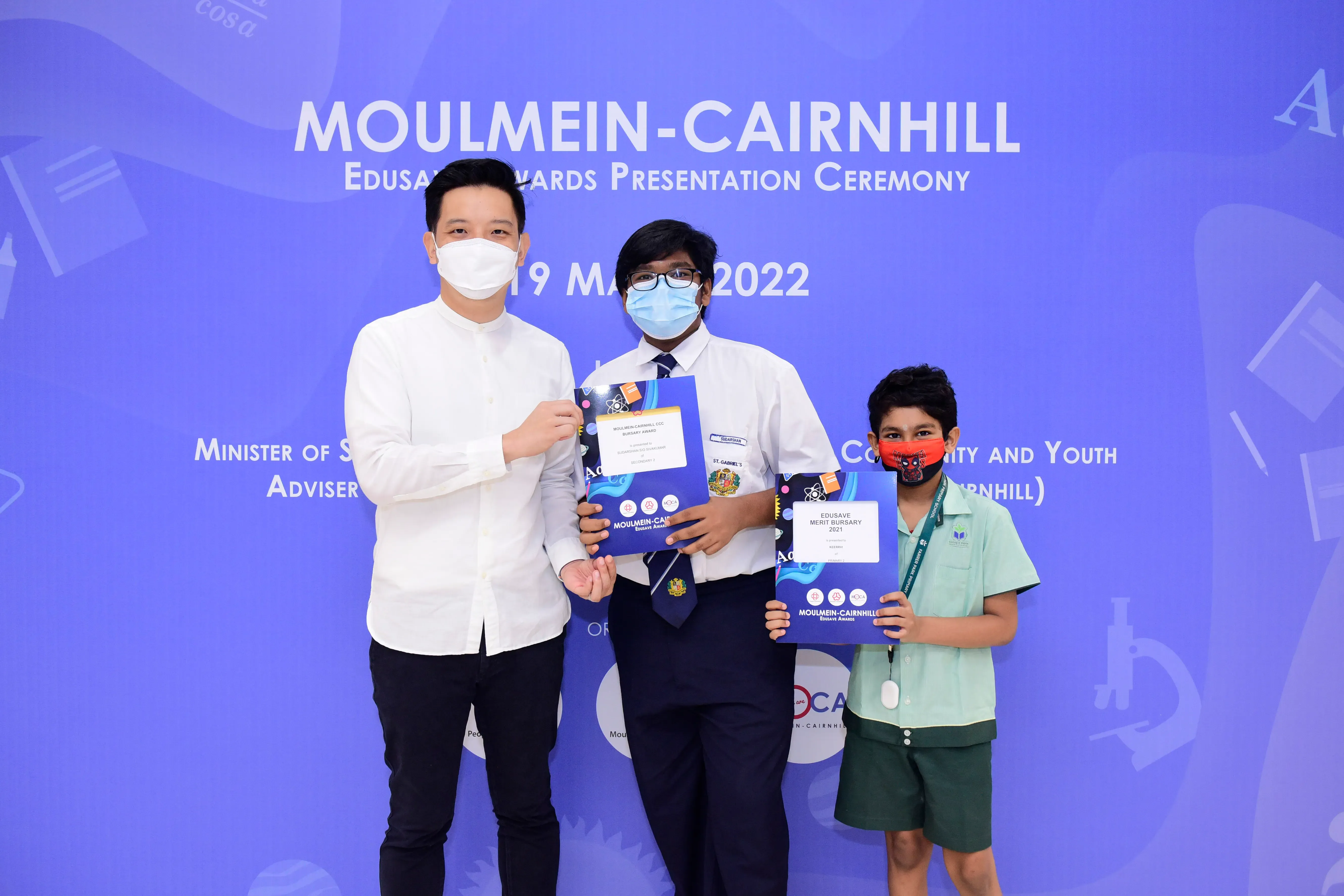 Three masked people pose at the Moulmein-Cairnhill Edusave Awards Presentation Ceremony on 19 May 2022.