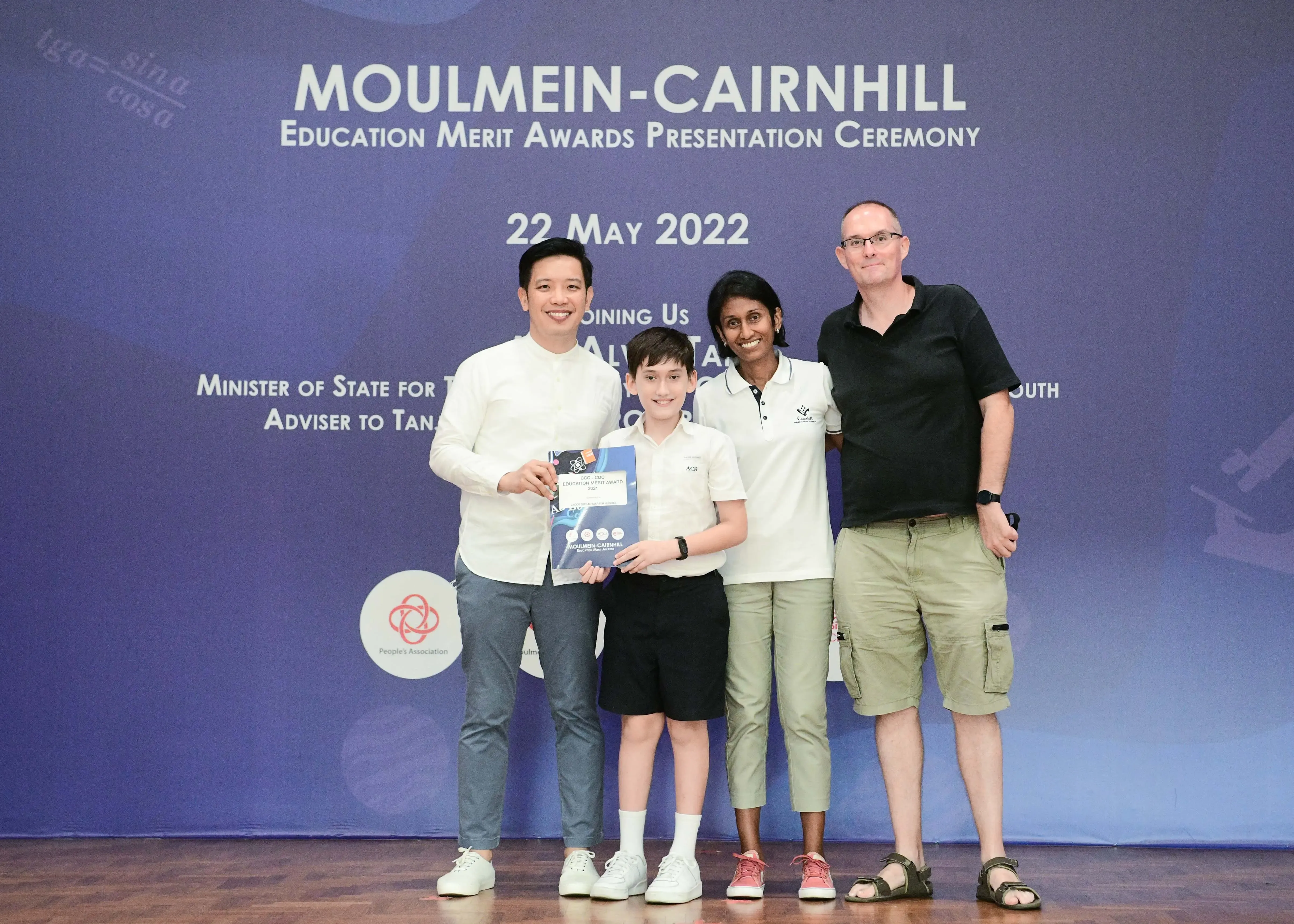 Four people pose with an award certificate at the Moulmein-Cairnhill Education Merit Awards Ceremony on 22 May 2022.
