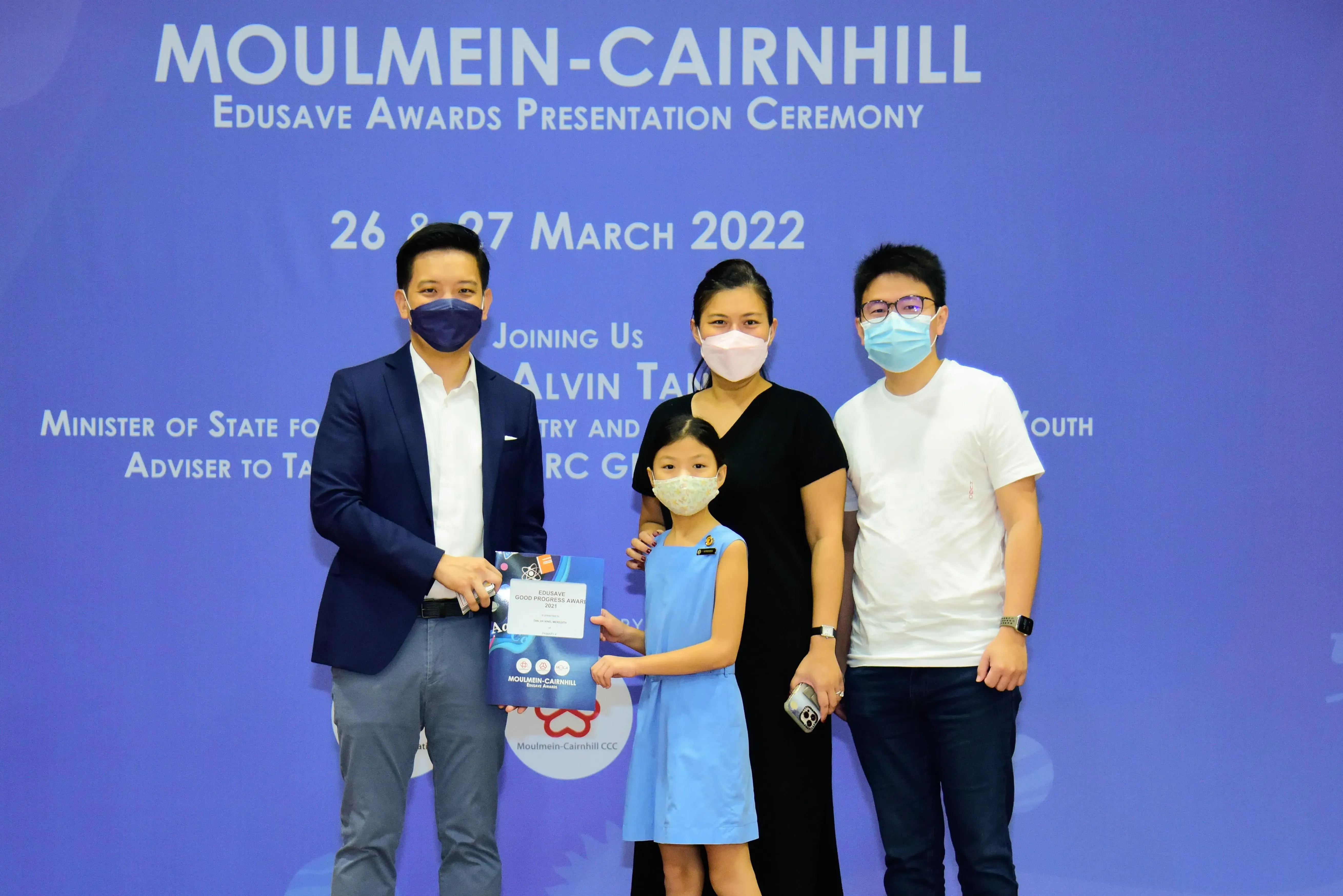 Four masked people pose at the Moulmein-Cairnhill Edusave Awards Presentation Ceremony on March 26-27, 2022.