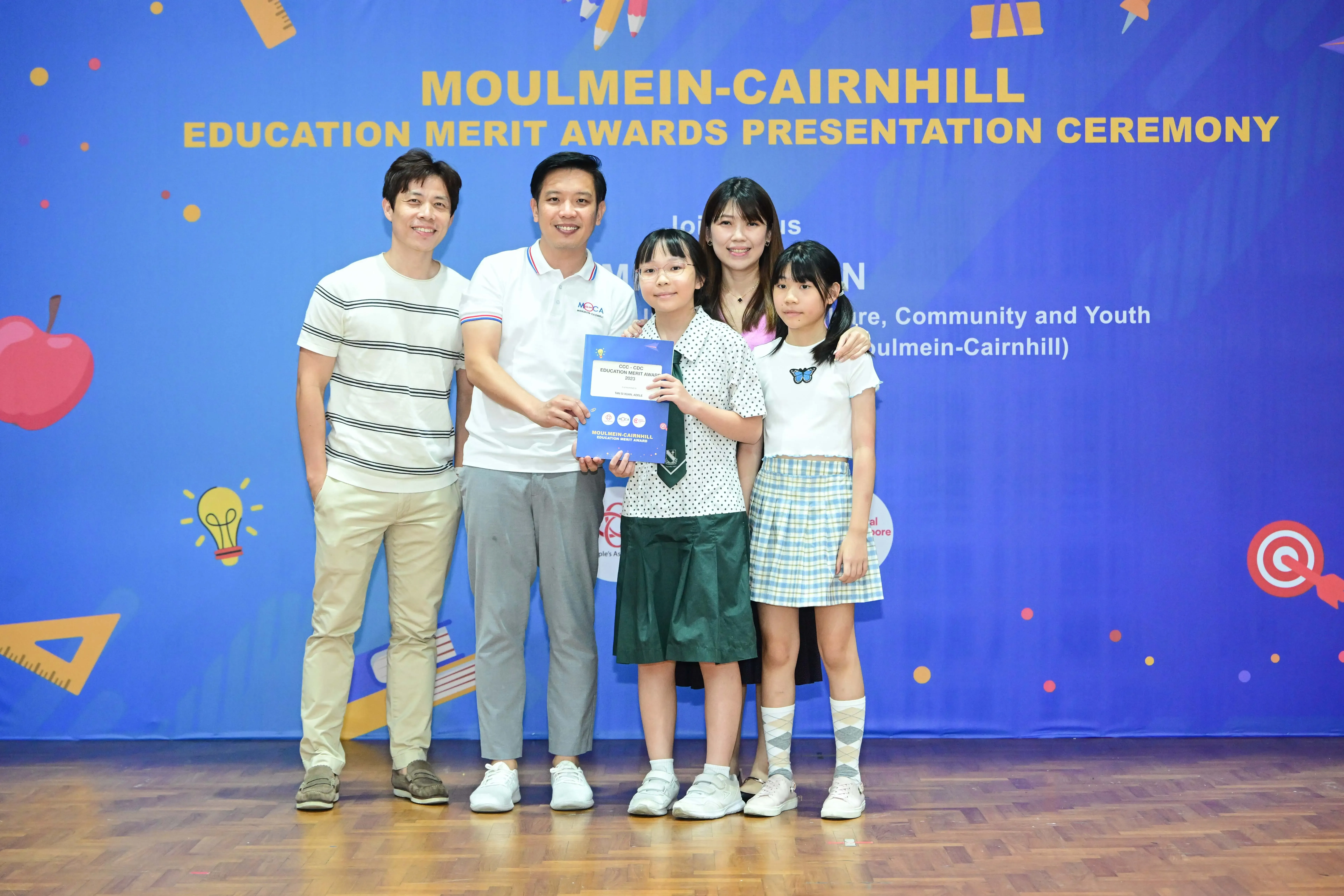 Five people pose with a certificate at the Moulmein-Cairnhill Education Merit Awards Presentation Ceremony.