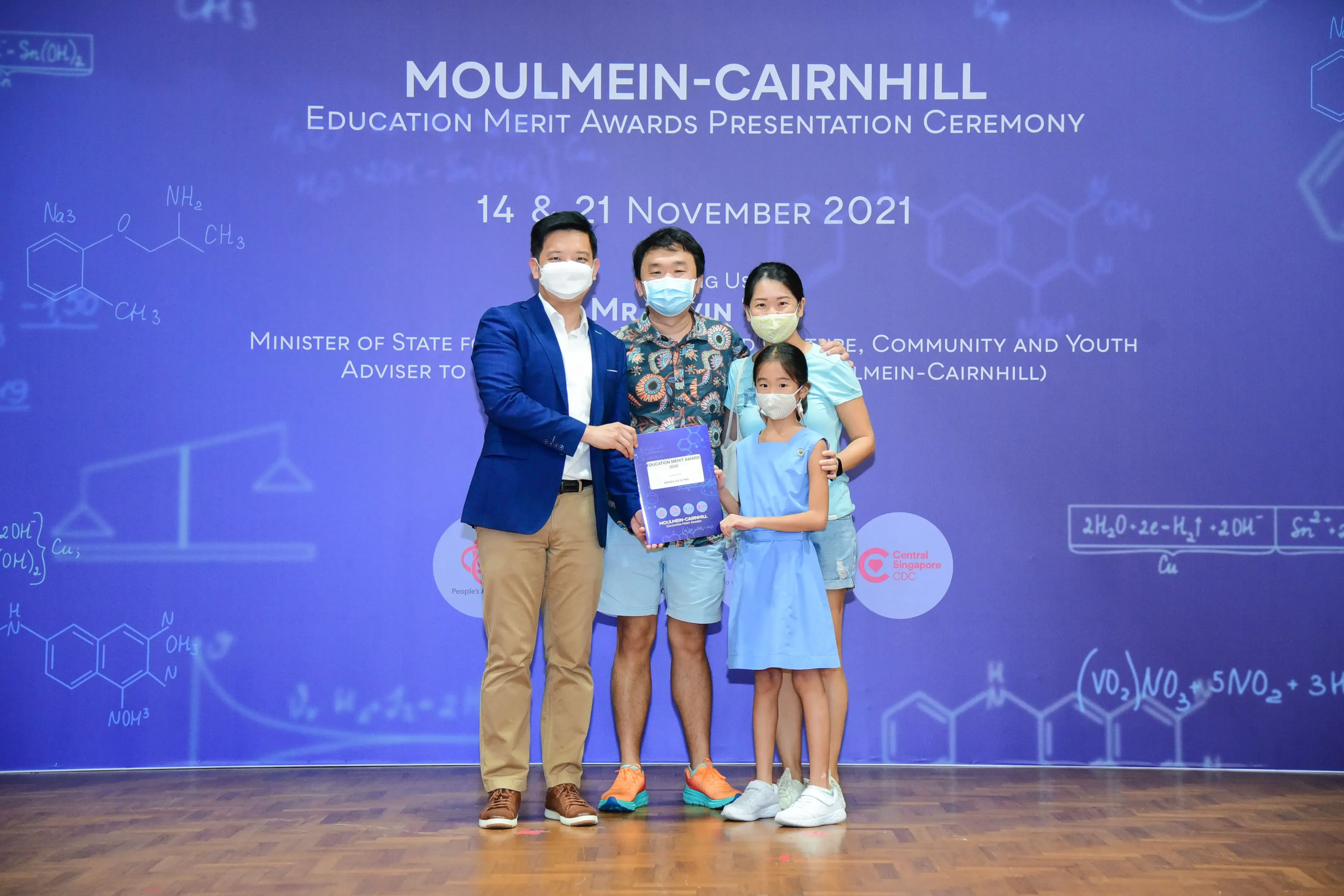 Four masked people pose at the Moulmein-Cairnhill Education Merit Awards Ceremony on 14 and 21 November 2021.