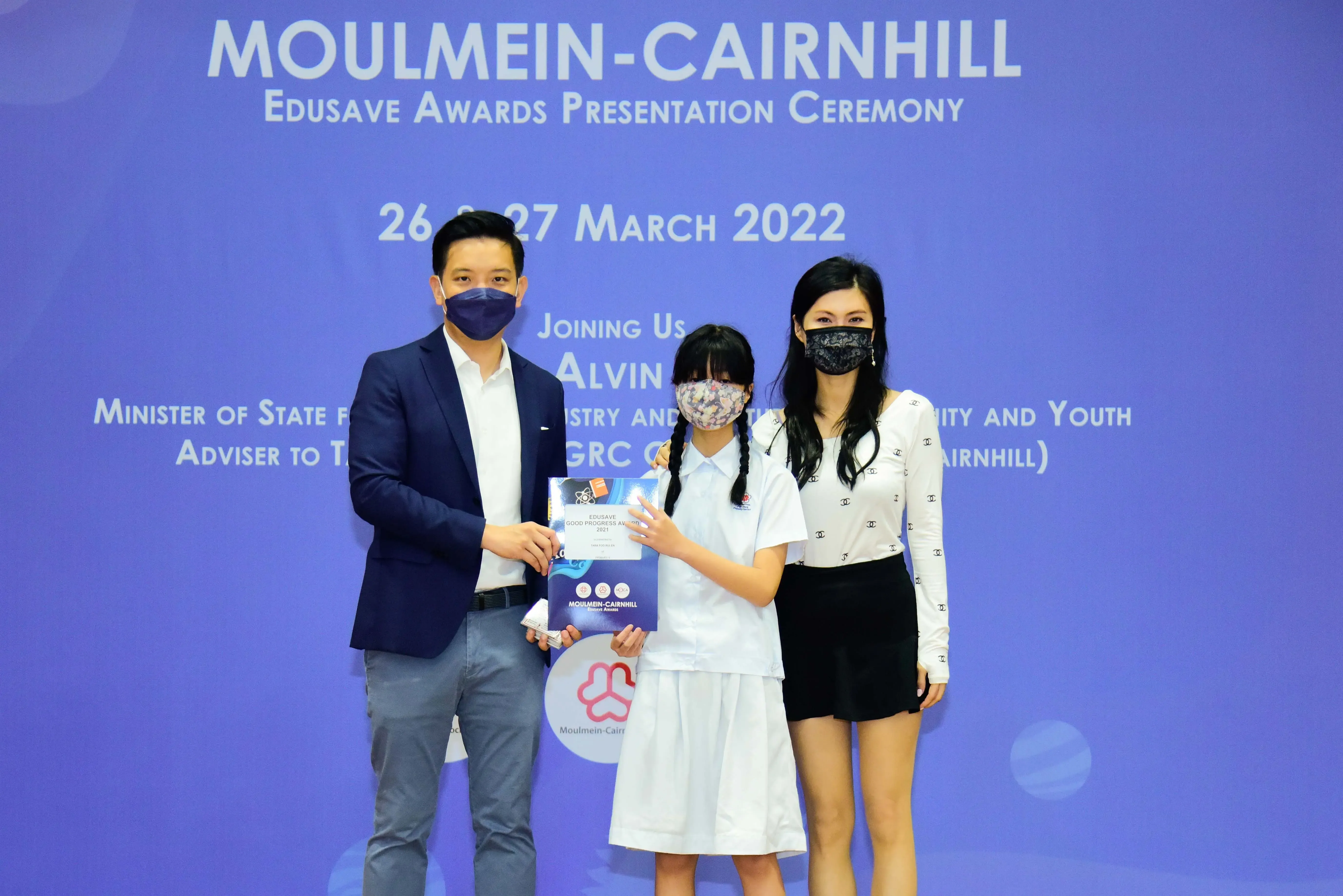 Three masked people pose at the Moulmein-Cairnhill Edusave Awards Presentation Ceremony on 26-27 March 2022.