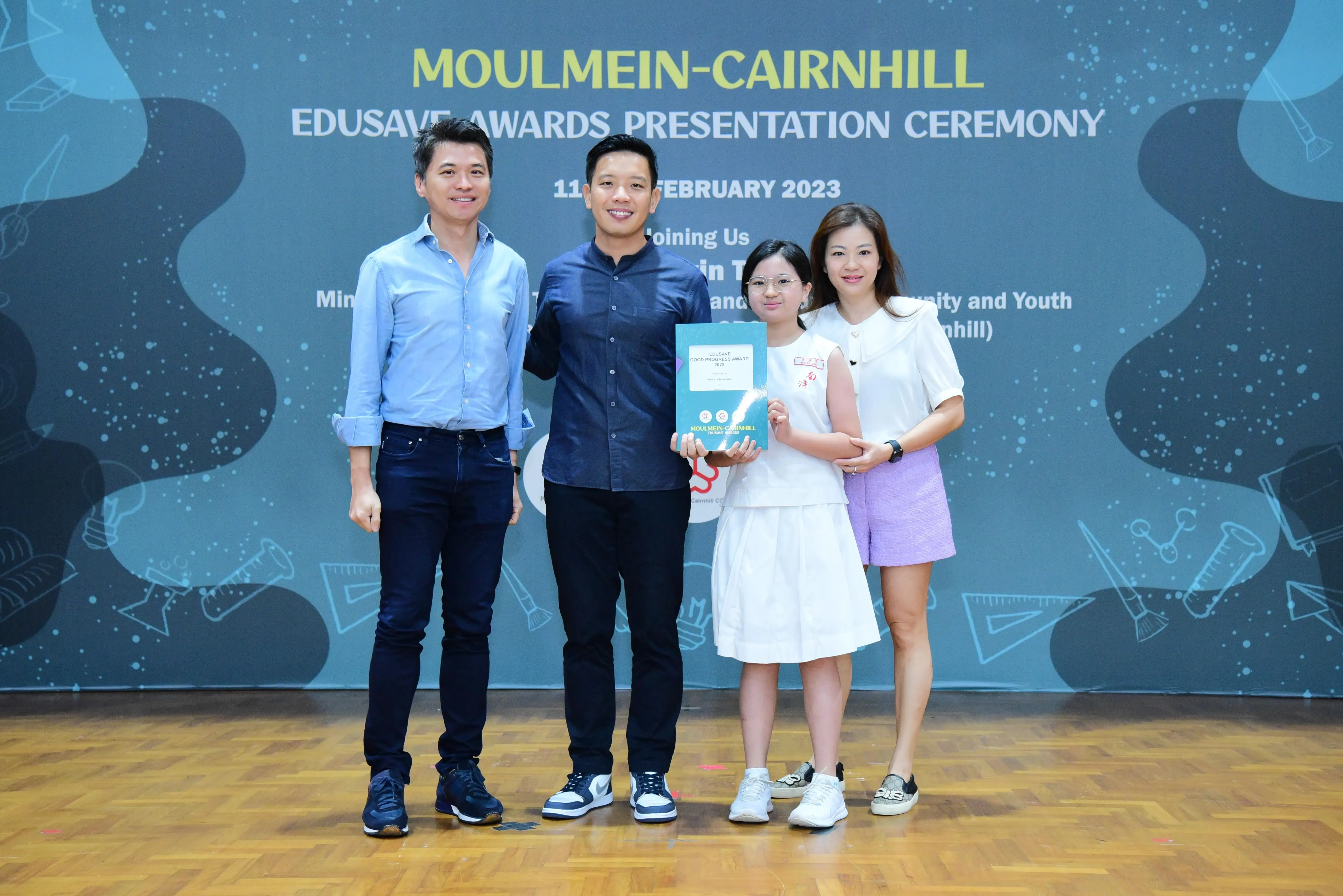 Four people pose holding an award at the Moulmein-Cairnhill Edusave Awards Presentation Ceremony, February 2023.