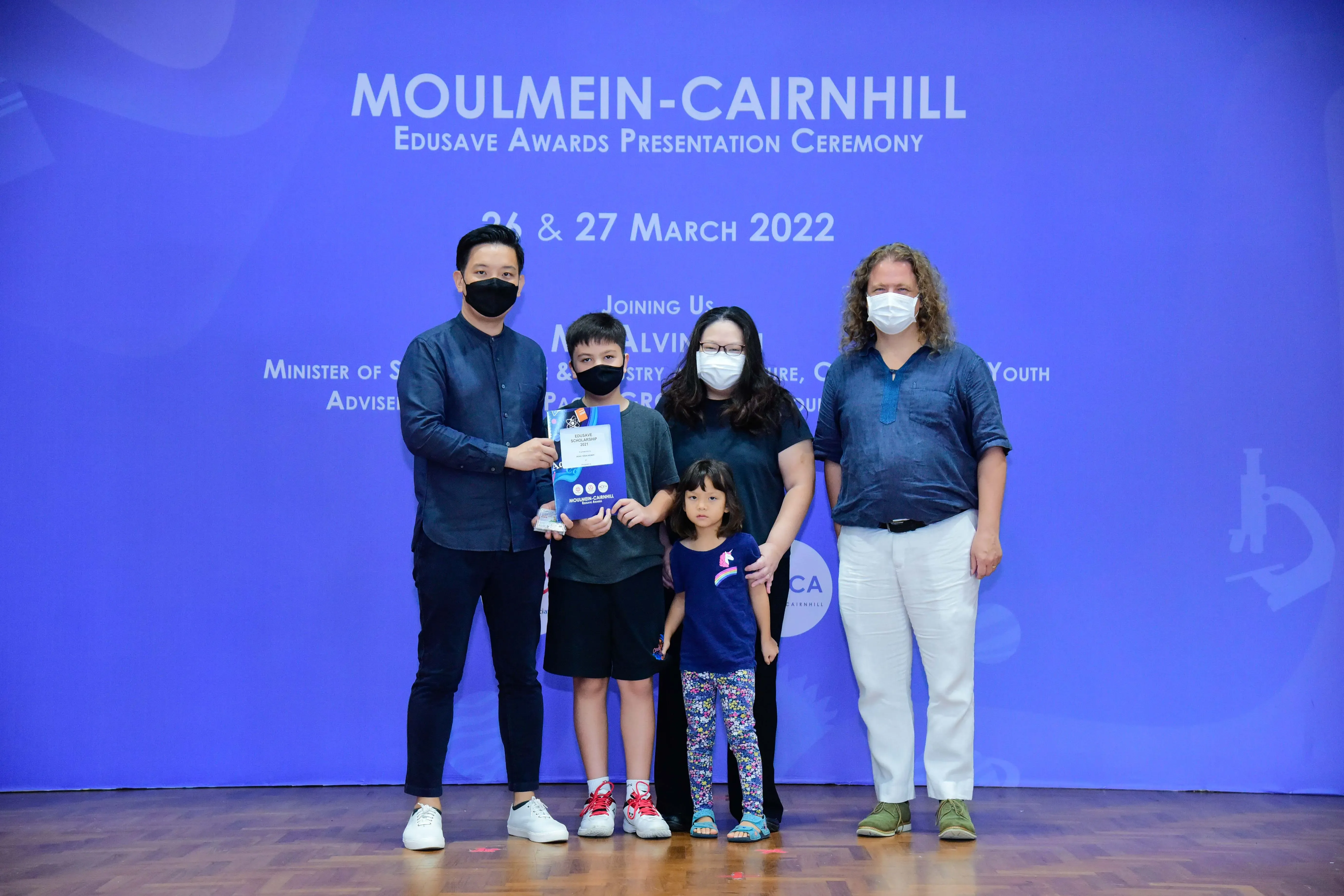 Five masked people pose at the Moulmein-Cairnhill Edusave Awards Presentation Ceremony on 26 & 27 March 2022.