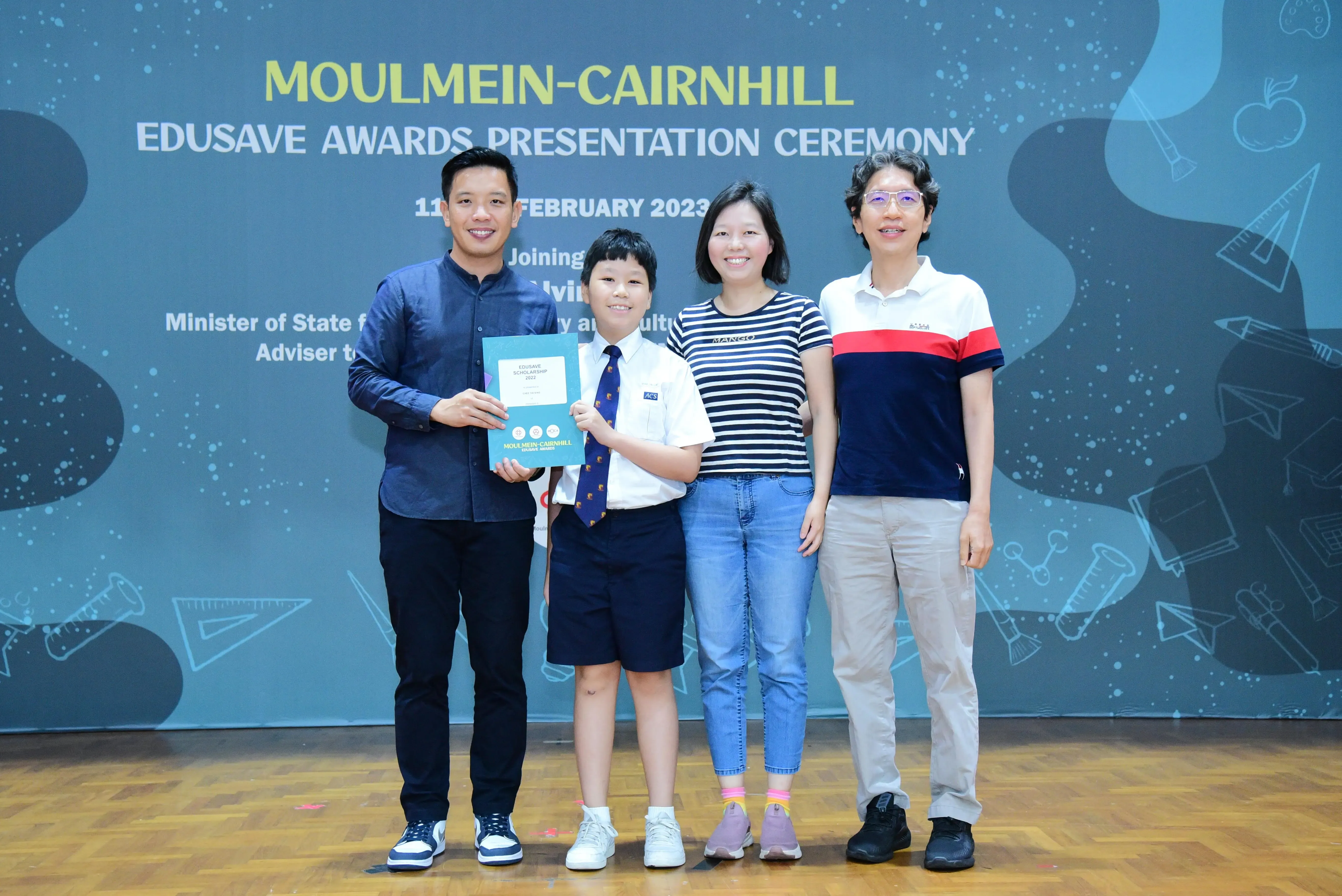 Four people pose with a certificate at the Moulmein-Cairnhill Edusave Awards Presentation Ceremony, February 2023.