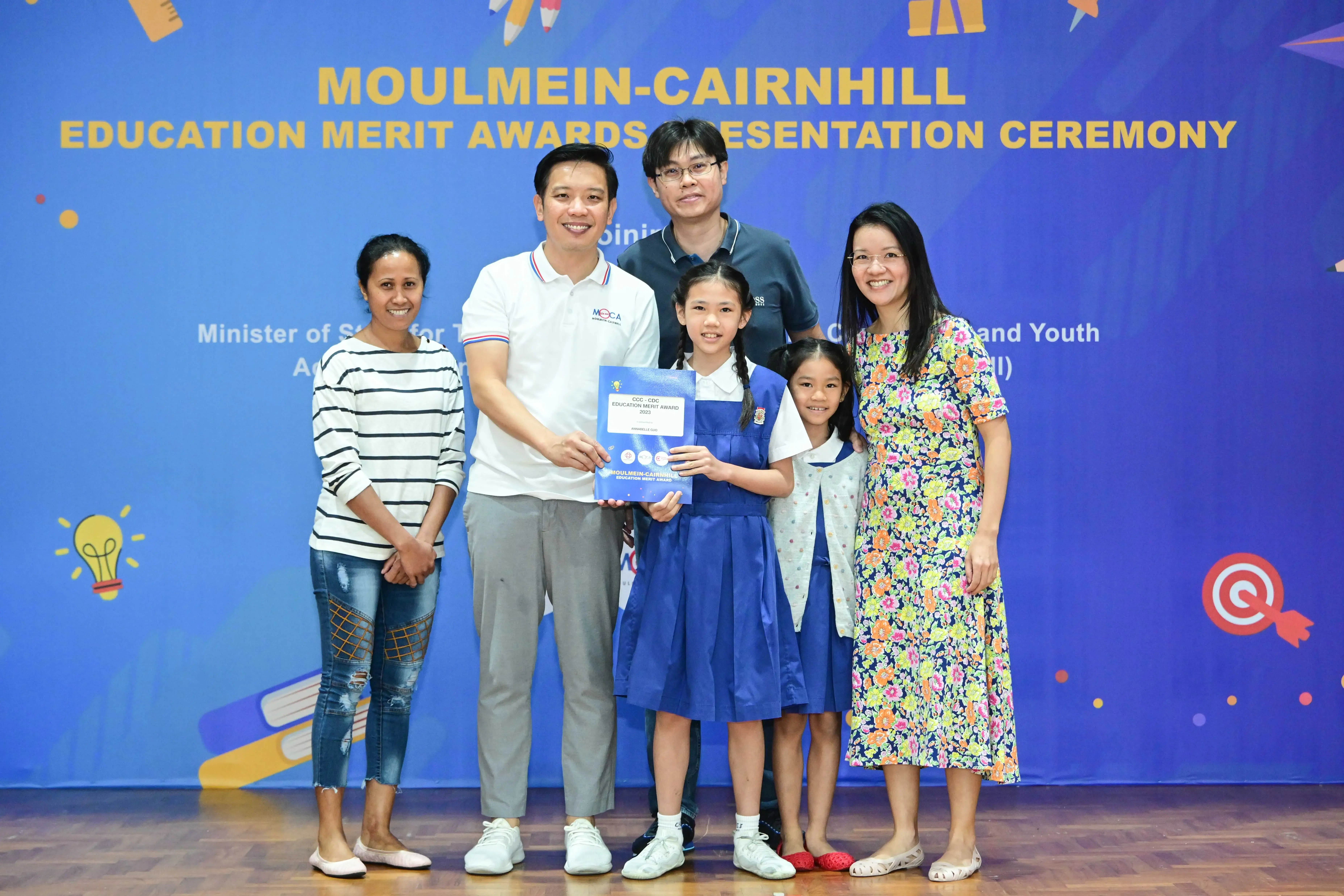 Group of adults and two children posing at the Moulmein-Cairnhill Education Merit Awards Presentation Ceremony.