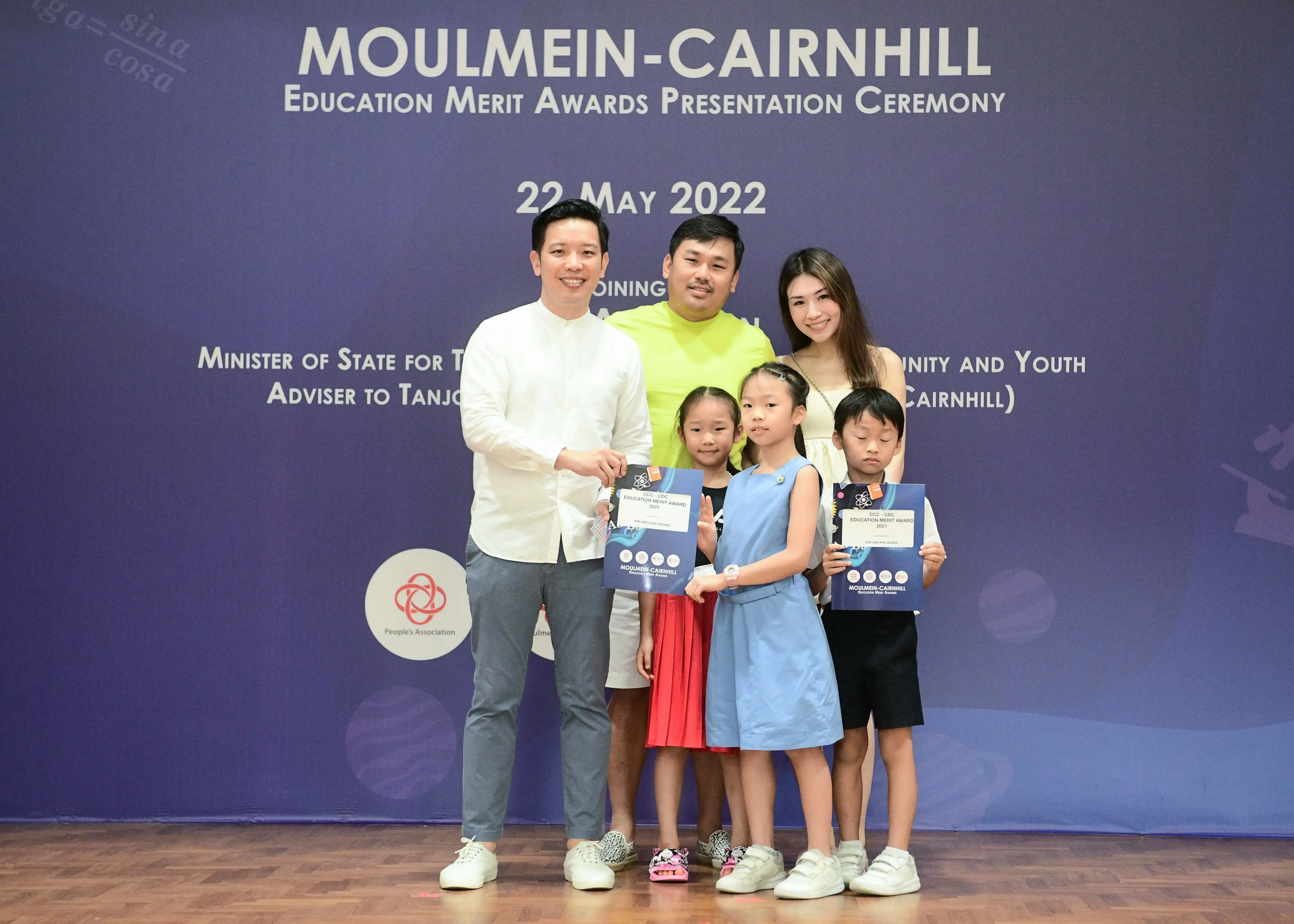 Three adults and three children pose with award certificates at the Moulmein-Cairnhill Education Merit Awards, May 2022.