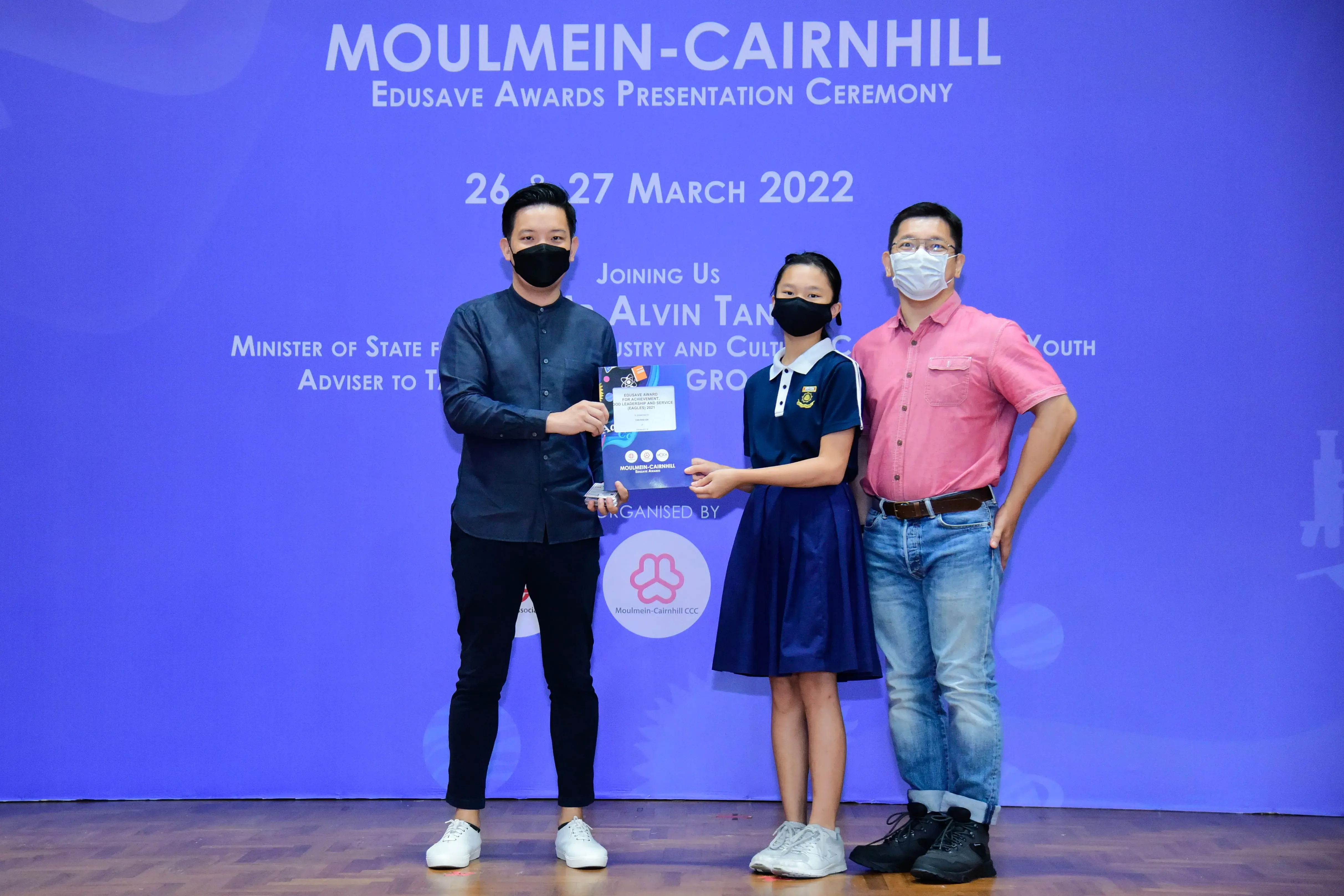Three masked people pose at the Moulmein-Cairnhill Edusave Awards Presentation Ceremony on 26-27 March 2022.