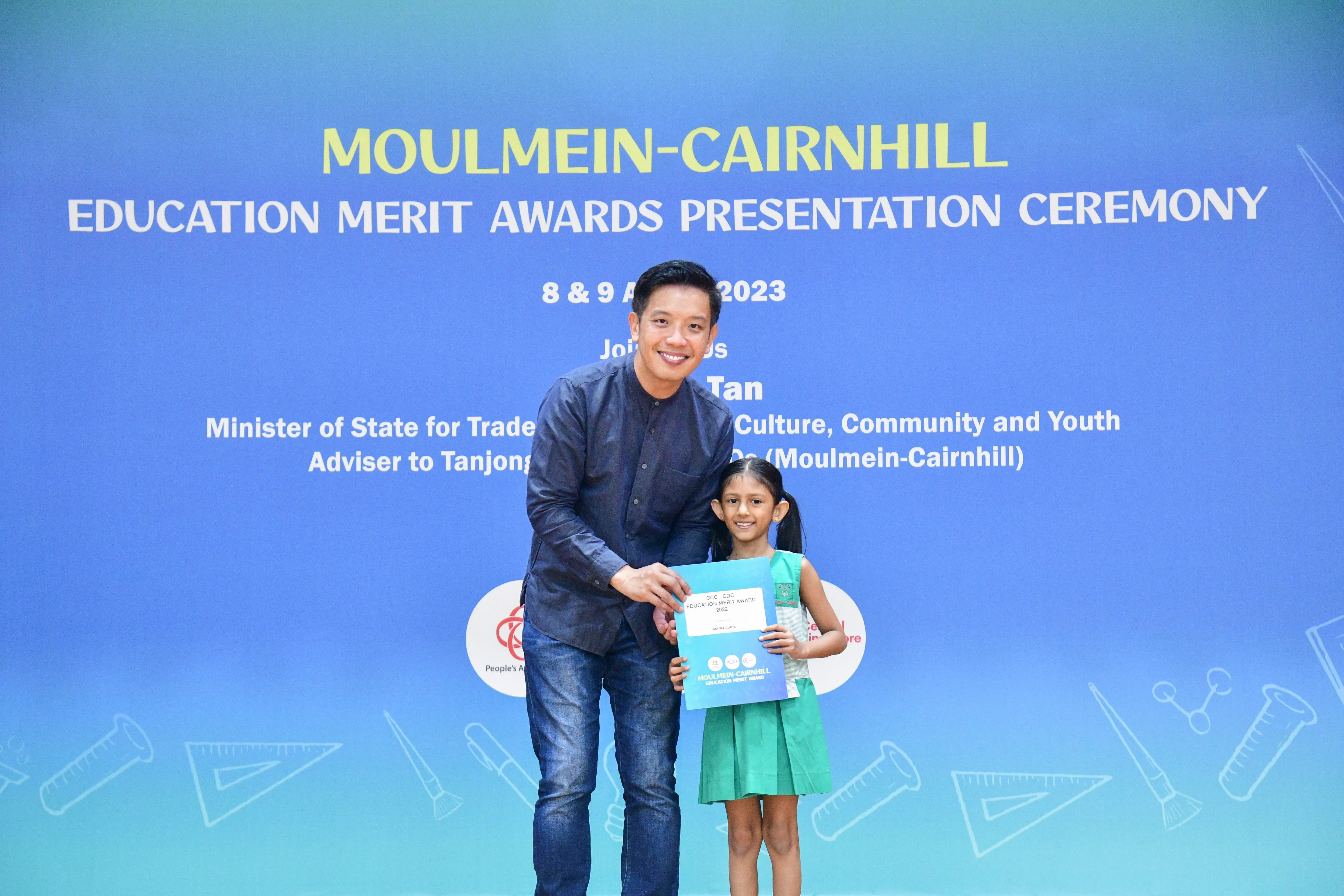 A man and a young girl pose together holding a certificate at the Moulmein-Cairnhill Education Merit Awards 2023.