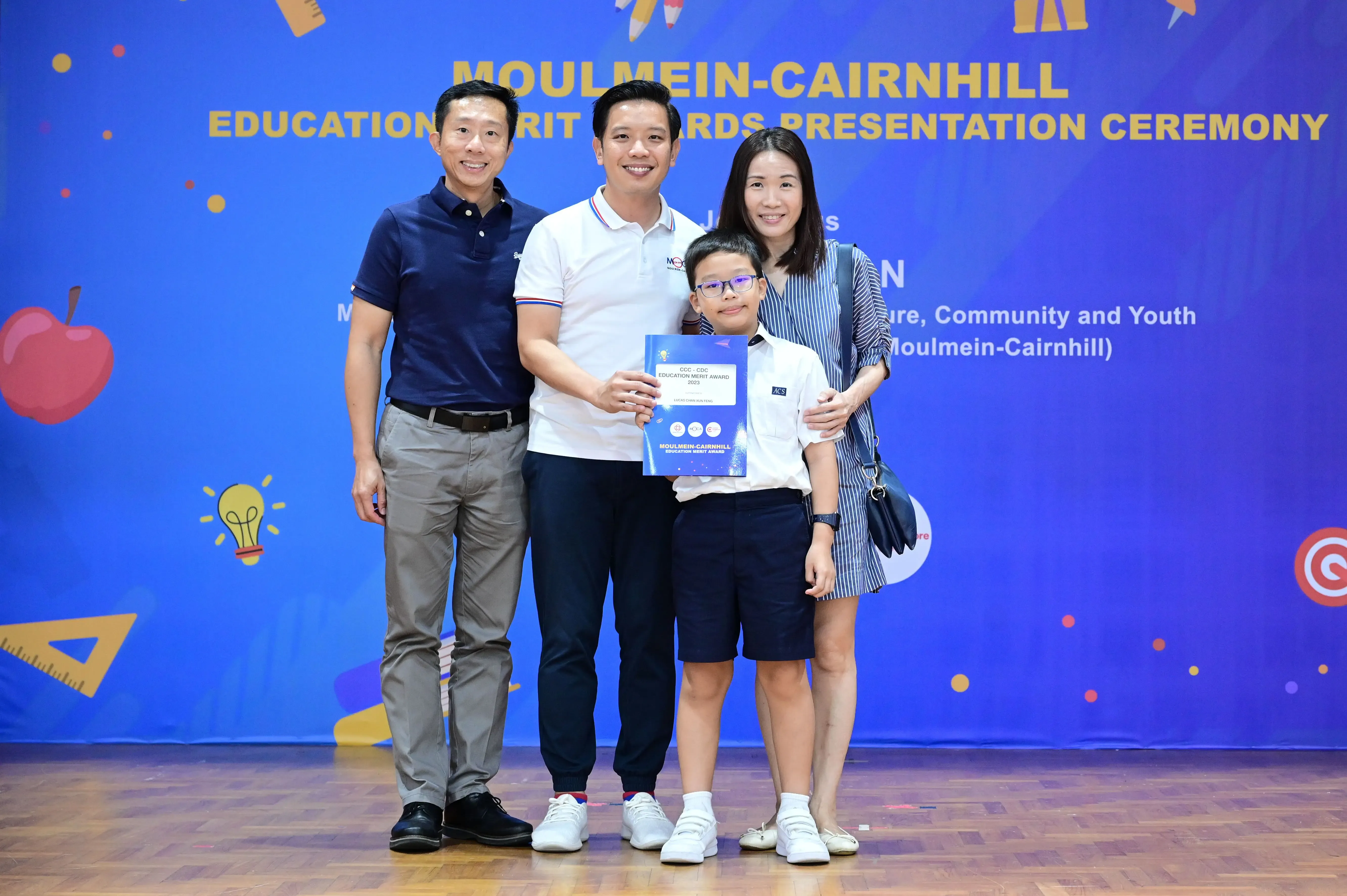 Four people pose with an award certificate at the Moulmein-Cairnhill Education Merit Awards Presentation Ceremony.