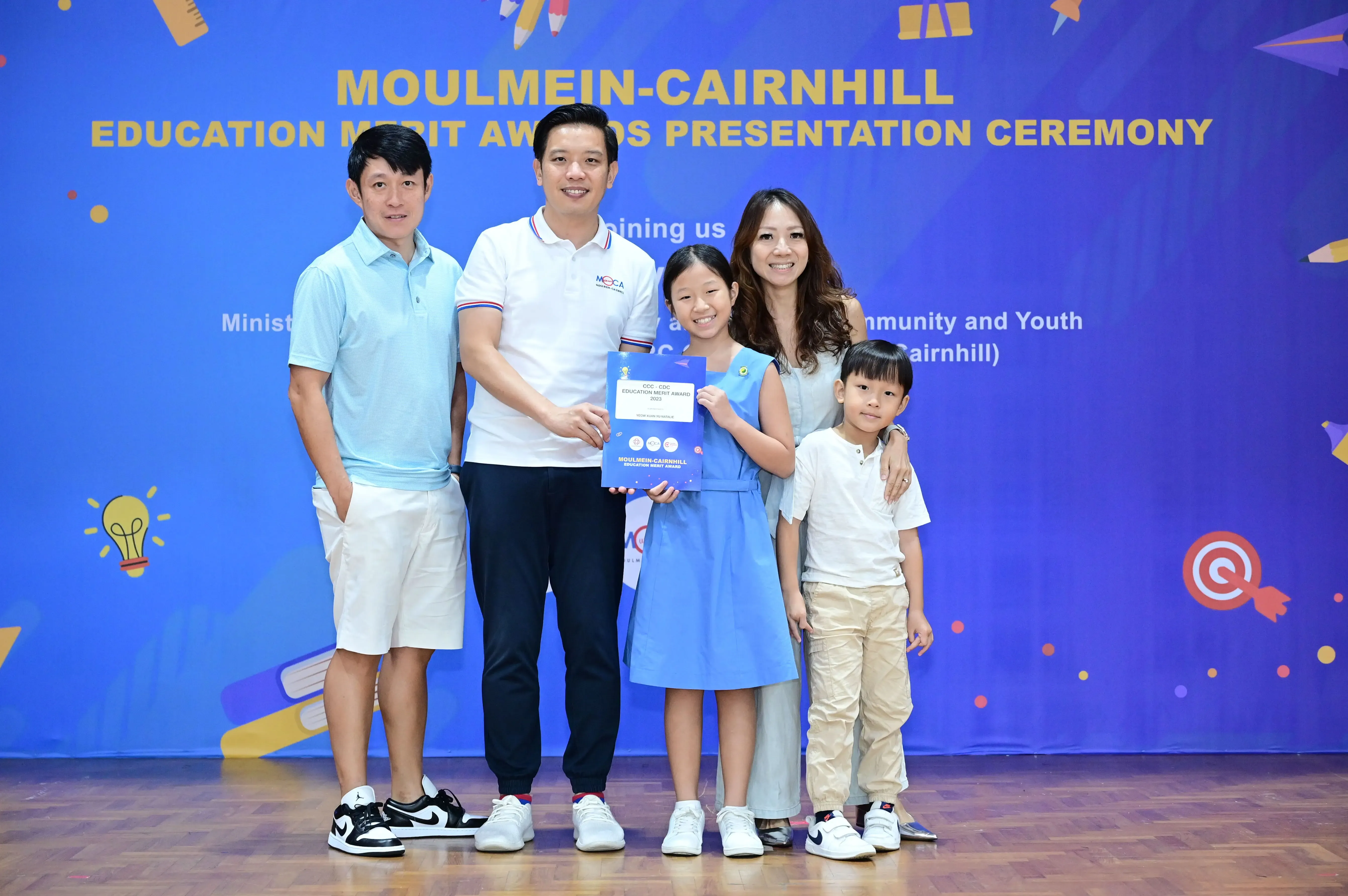 Five people pose with an award certificate at the Moulmein-Cairnhill Education Merit Awards Presentation Ceremony.
