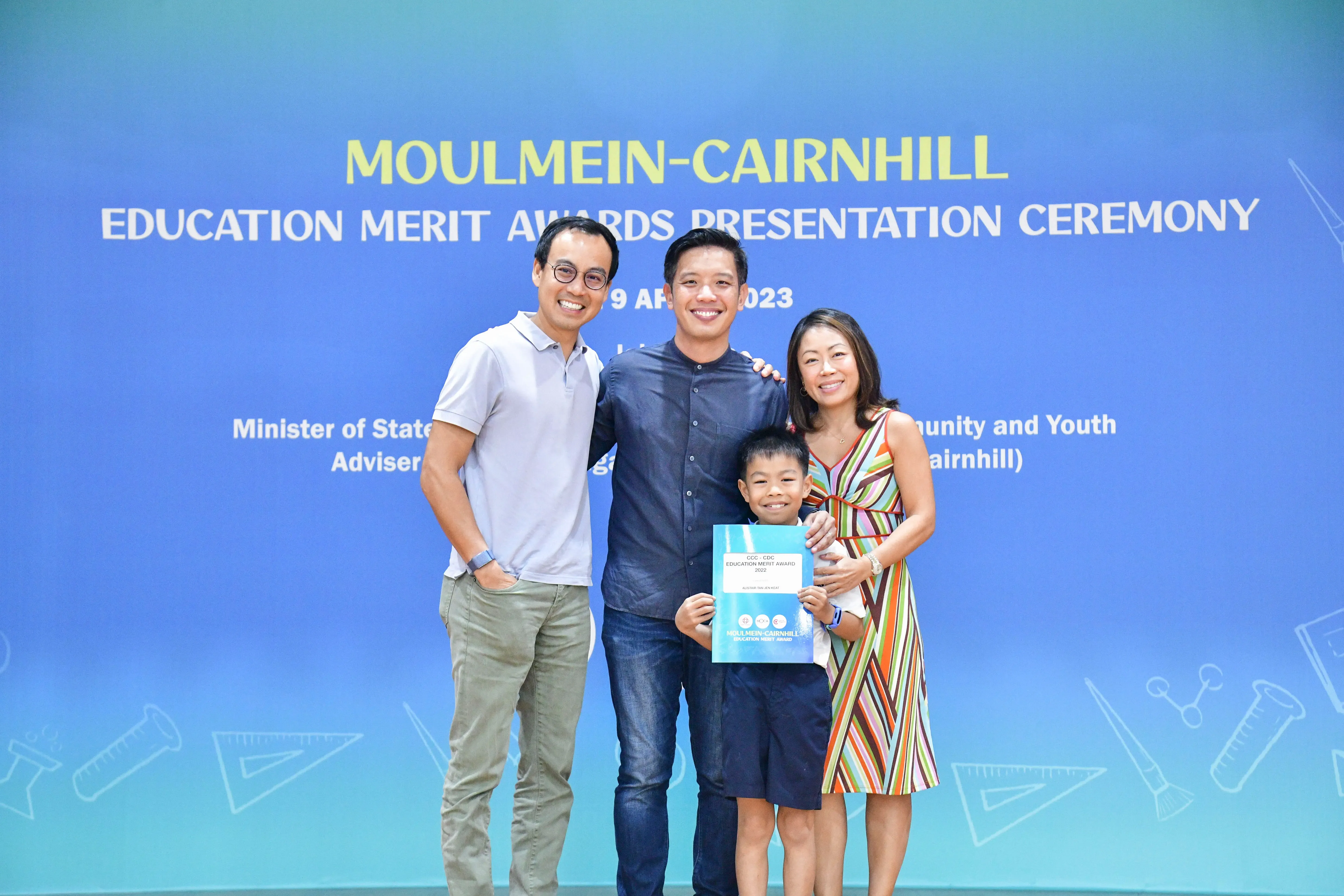 Three adults and a boy holding an award certificate pose at the Moulmein-Cairnhill Education Merit Awards 2023.
