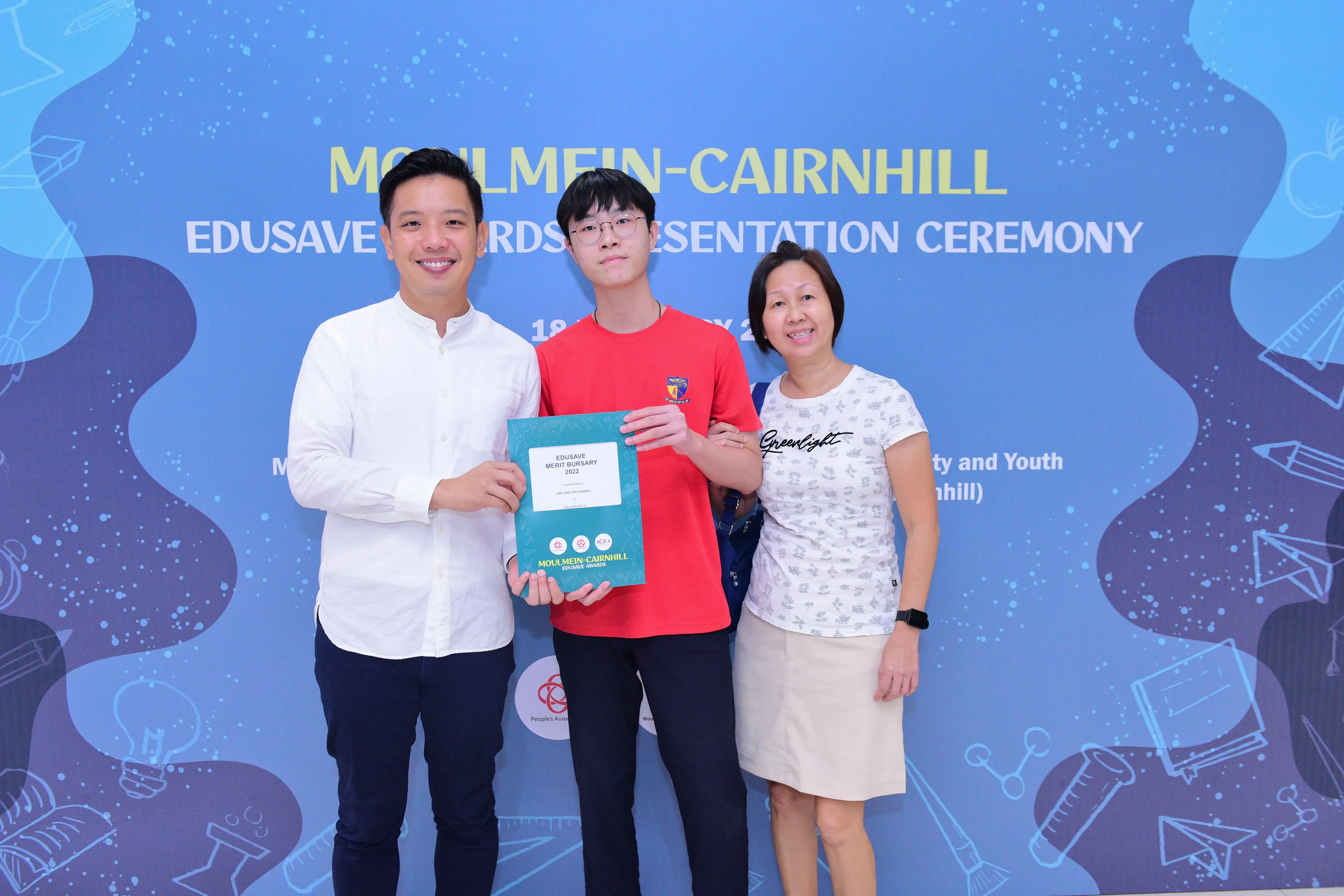 Three people pose at the Moulmein-Cairnhill Edusave Awards Presentation Ceremony, with a student holding a certificate.