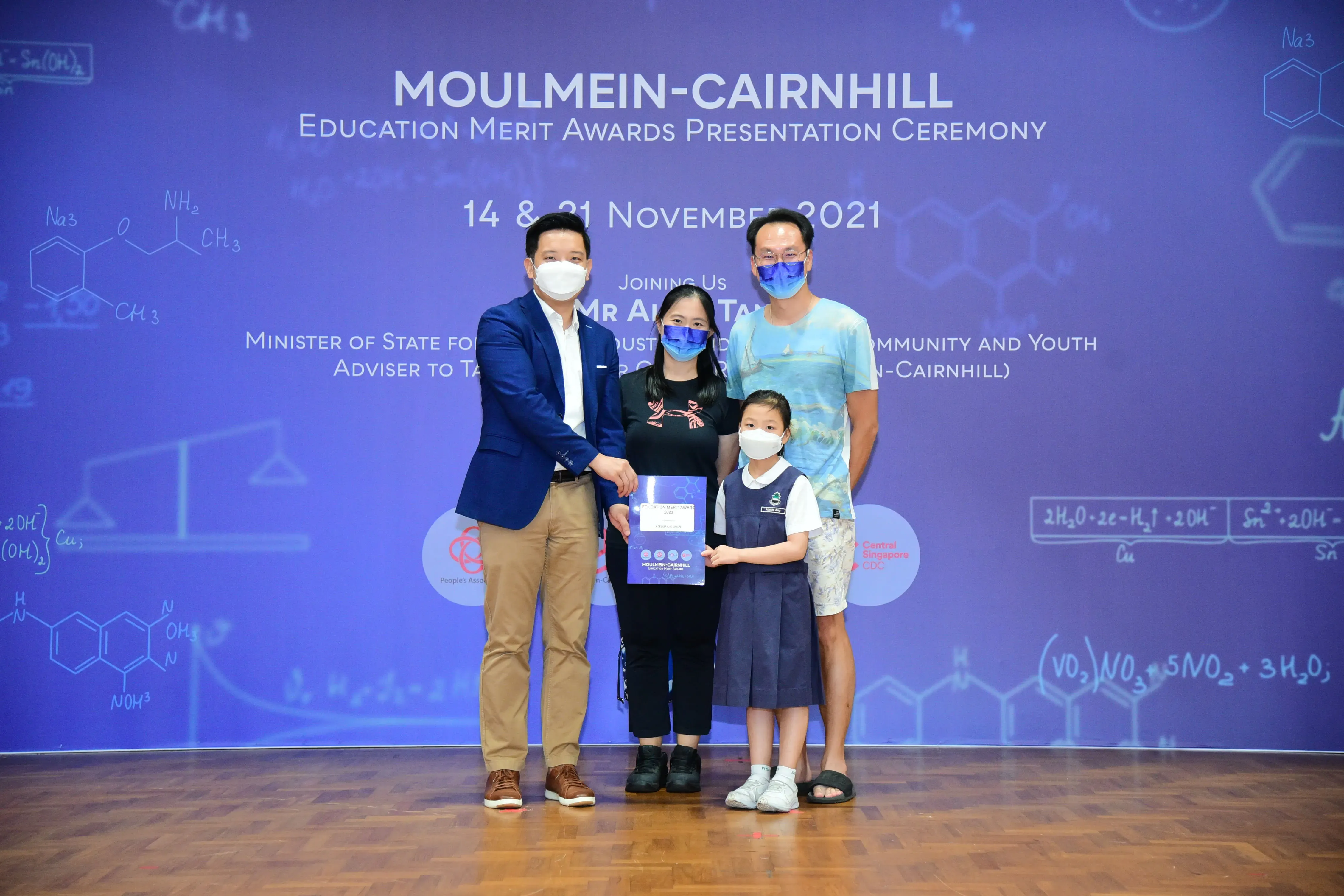 Four masked people pose with an award at the Moulmein-Cairnhill Education Merit Awards Ceremony, November 2021.