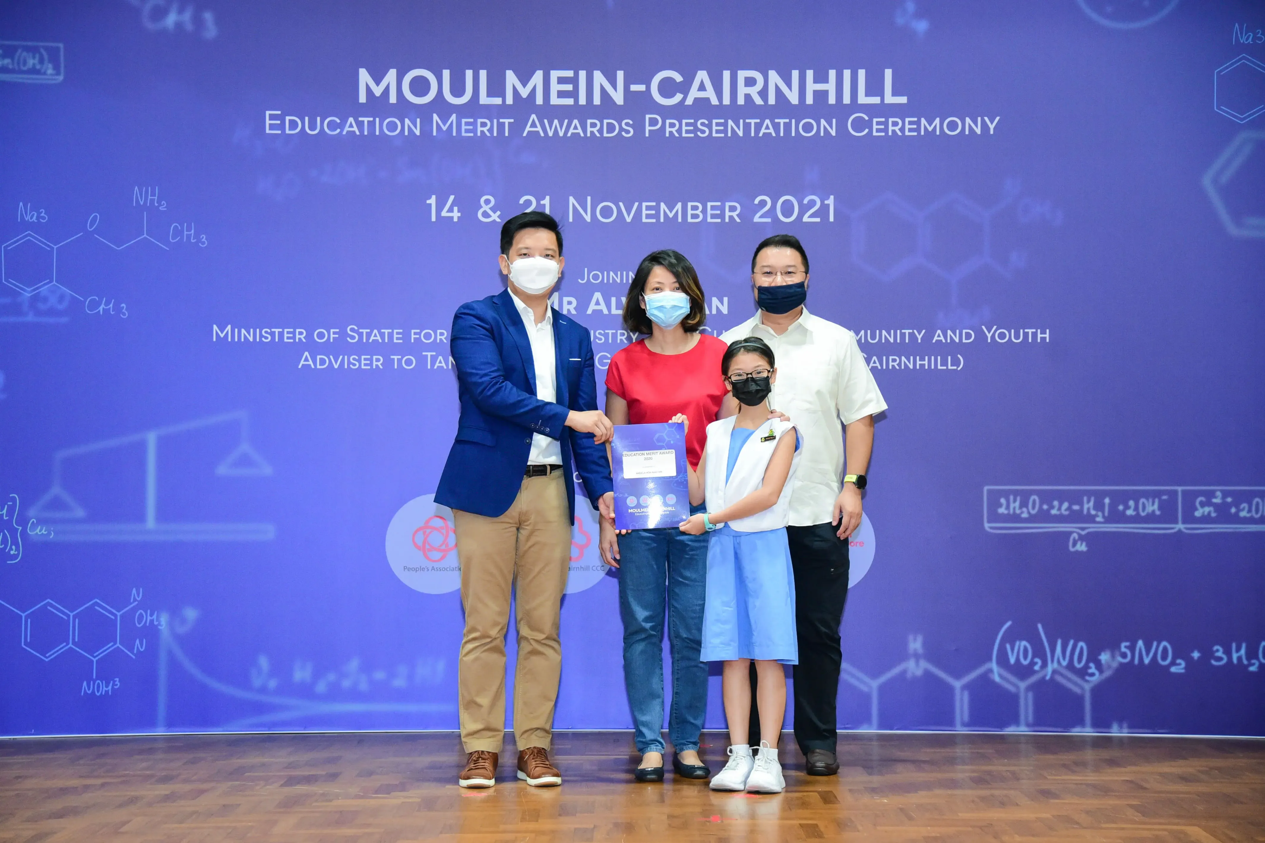 Four masked people pose at the Moulmein-Cairnhill Education Merit Awards ceremony on 14 and 21 November 2021.
