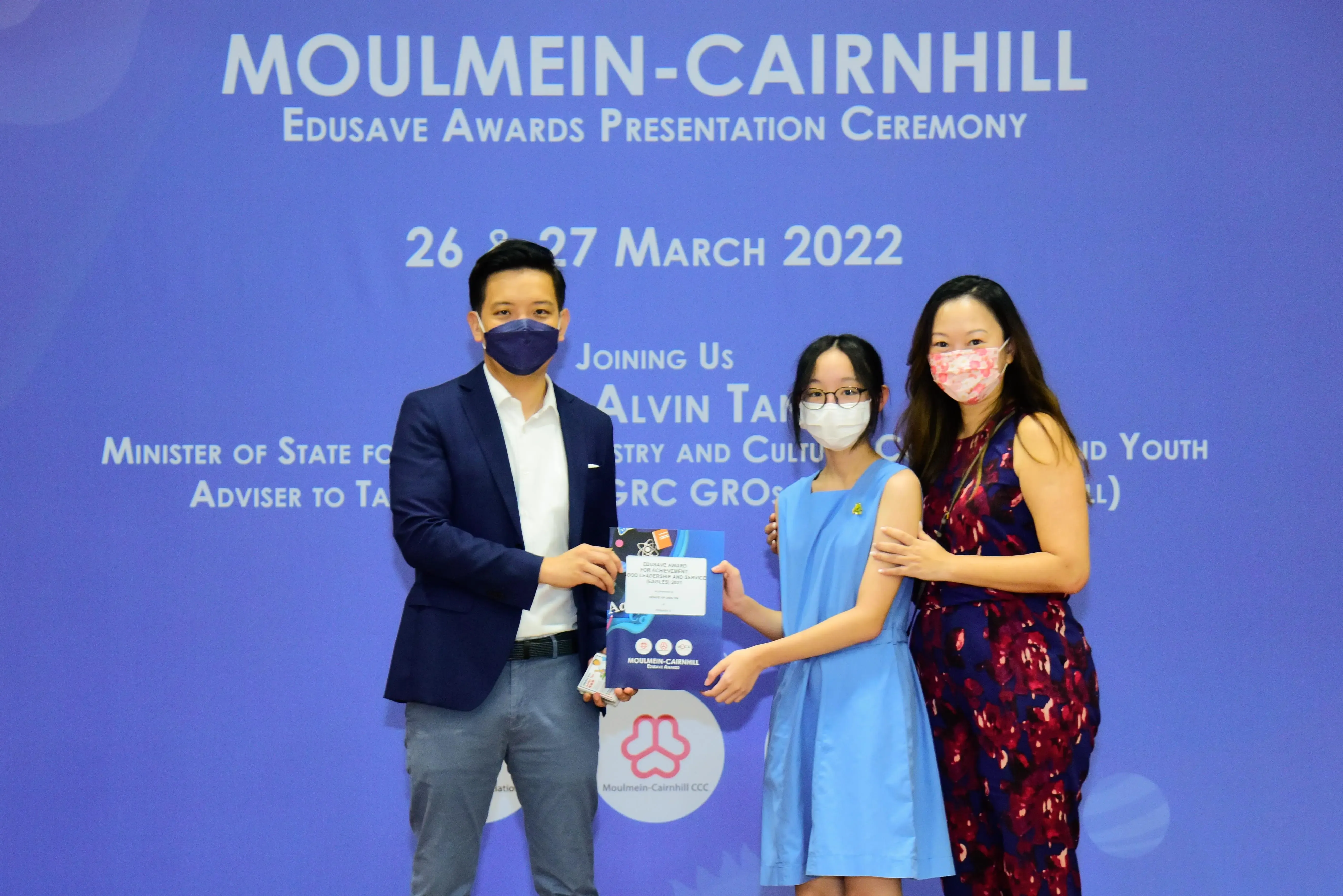 Three masked people pose at the Moulmein-Cairnhill Edusave Awards Presentation Ceremony on 26-27 March 2022.