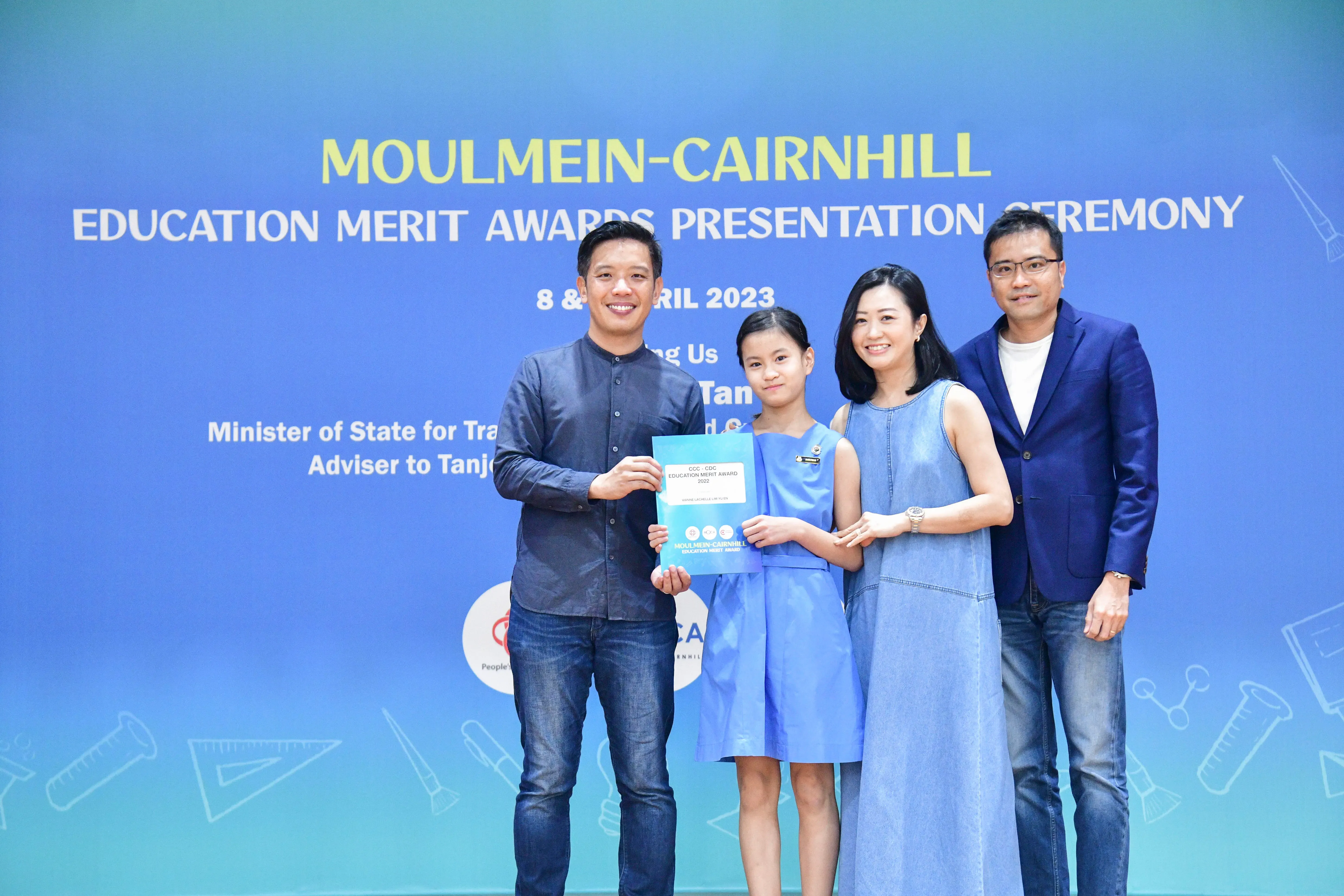 Four people pose with an award certificate at the Moulmein-Cairnhill Education Merit Awards Ceremony, April 2023.