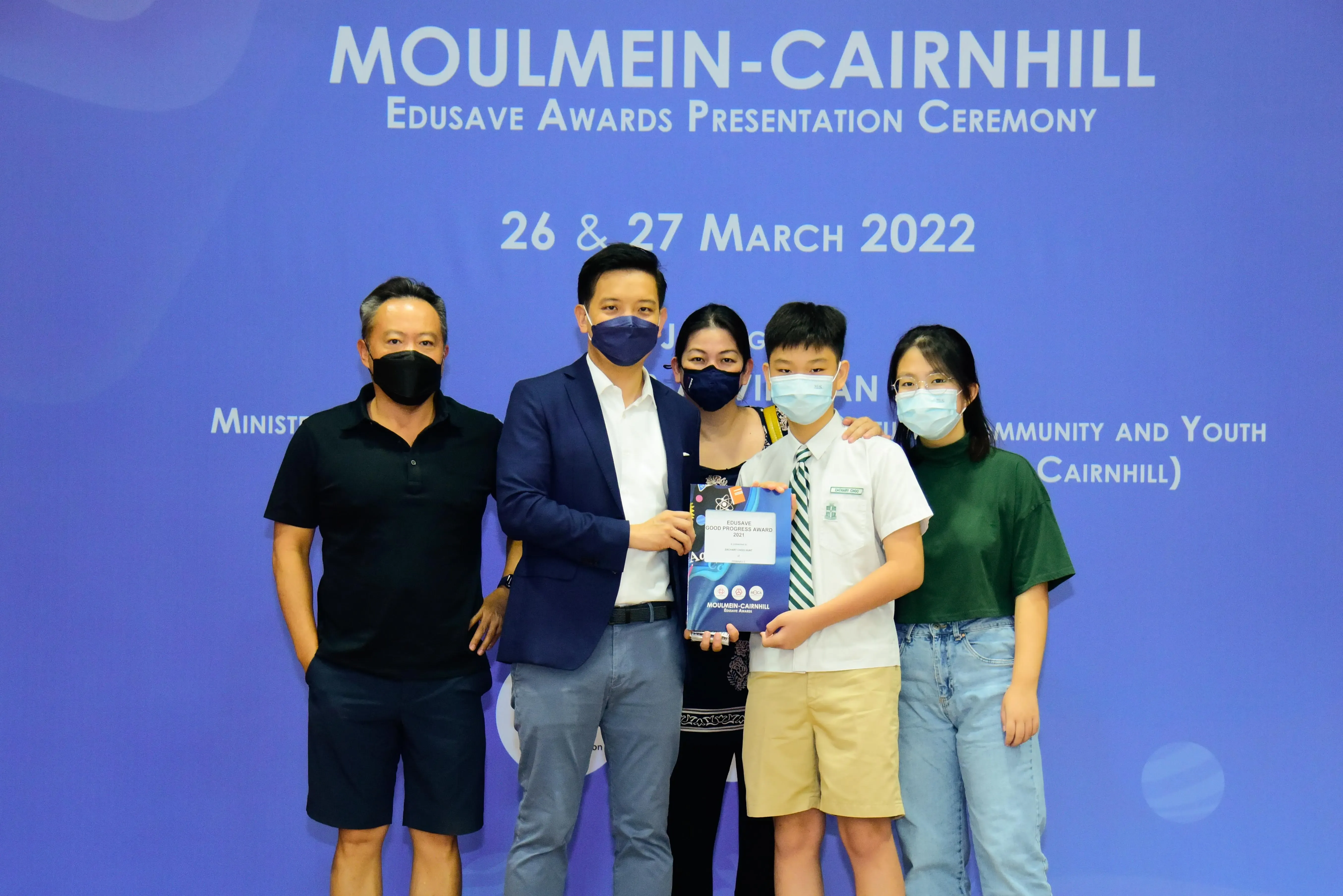 Five masked people pose at the Moulmein-Cairnhill Edusave Awards Presentation Ceremony on 26-27 March 2022.