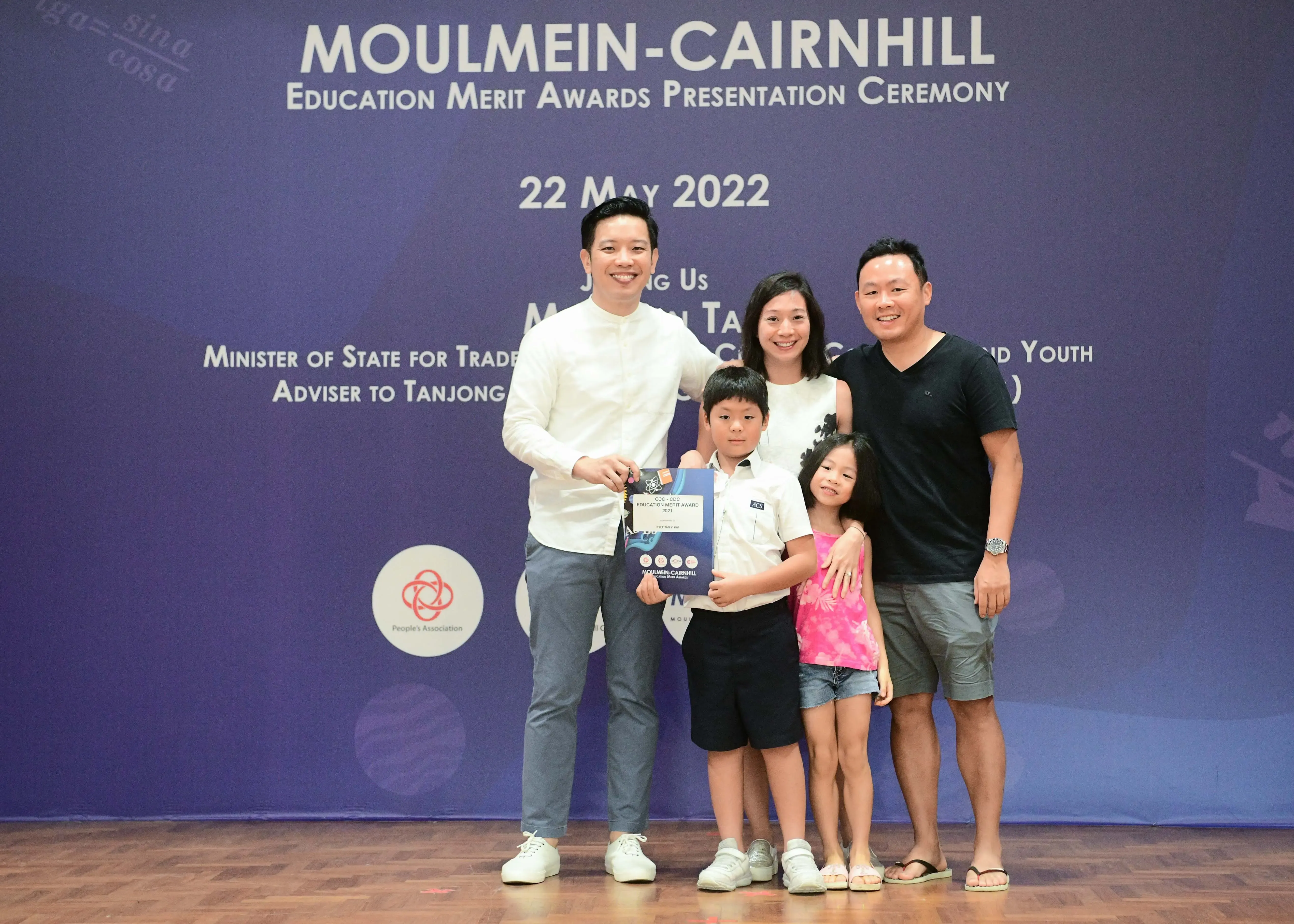 Five people pose with an award certificate at the Moulmein-Cairnhill Education Merit Awards Ceremony on 22 May 2022.
