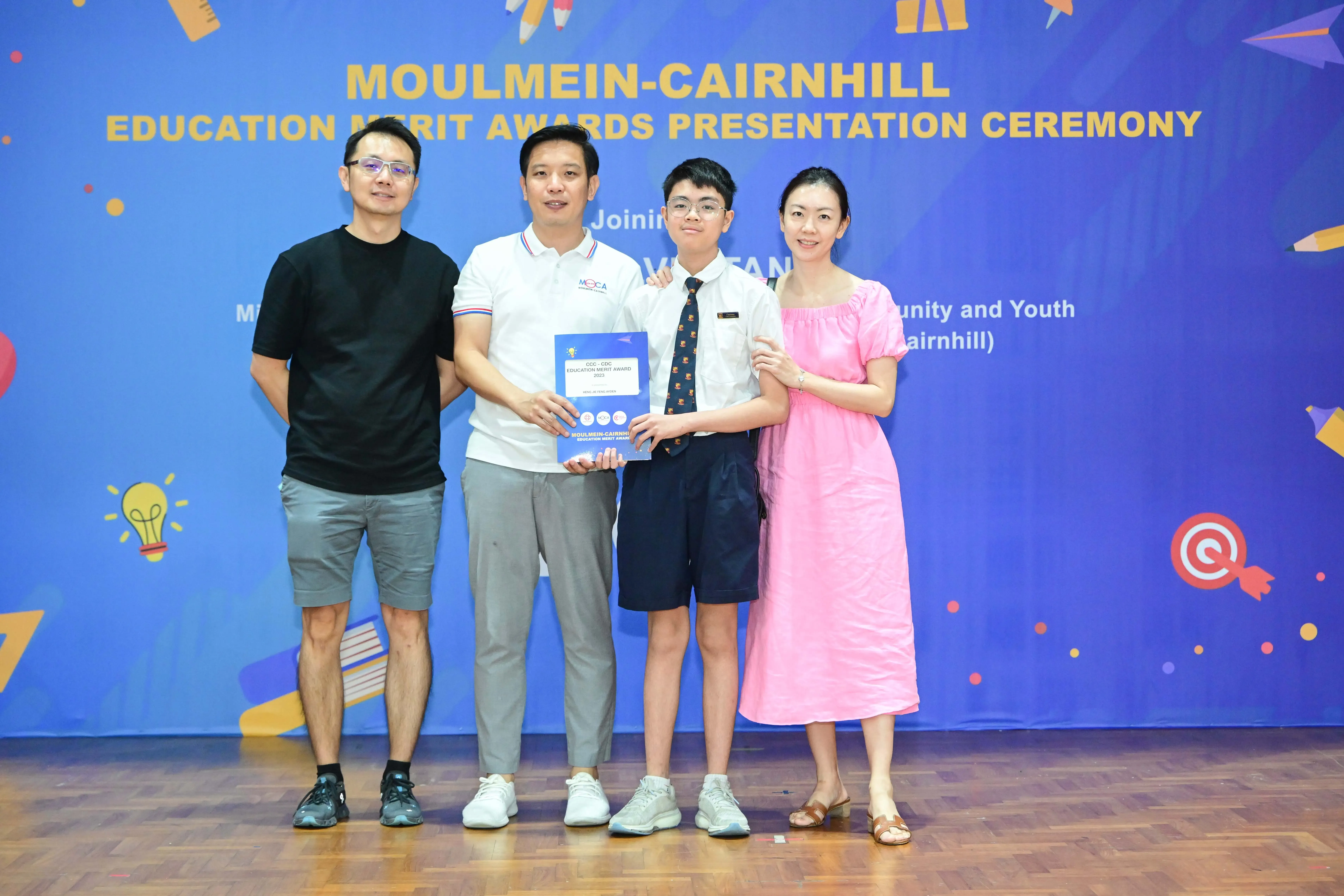 Four people pose with an award certificate at the Moulmein-Cairnhill Education Merit Awards Presentation Ceremony.