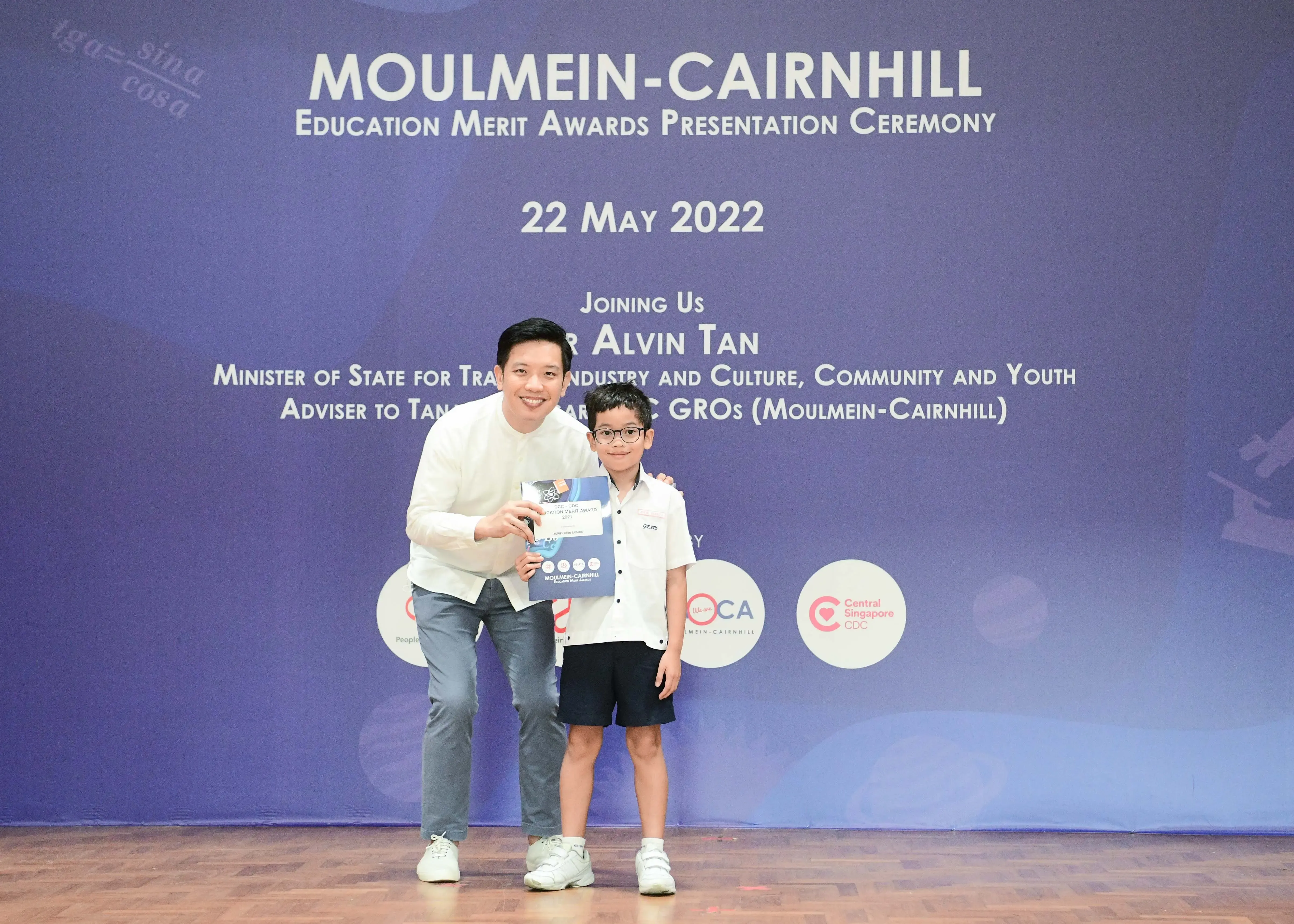 A man and a young boy pose together holding a certificate at the Moulmein-Cairnhill Education Merit Awards on 22 May 2022.